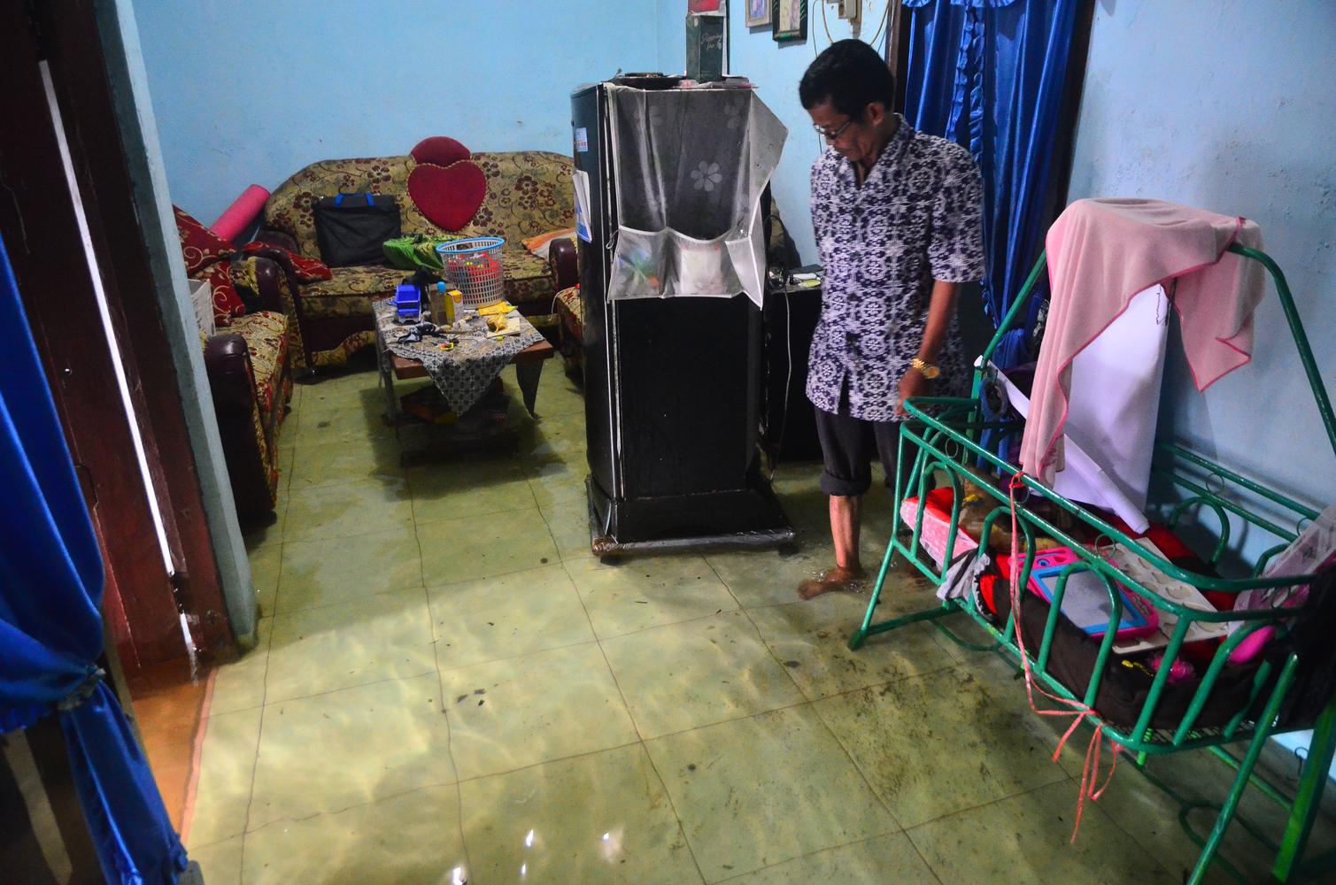 Warga mengecek rumah yang terendam banjir di Desa Jati Wetan, Kudus, Jawa Tengah, Kamis (10/12/2020). Akibat intensitas hujan yang tinggi sebanyak 75 rumah di wilayah itu terendam banjir dengan ketinggian 15-60 centimeter sejak dua hari terakhir.