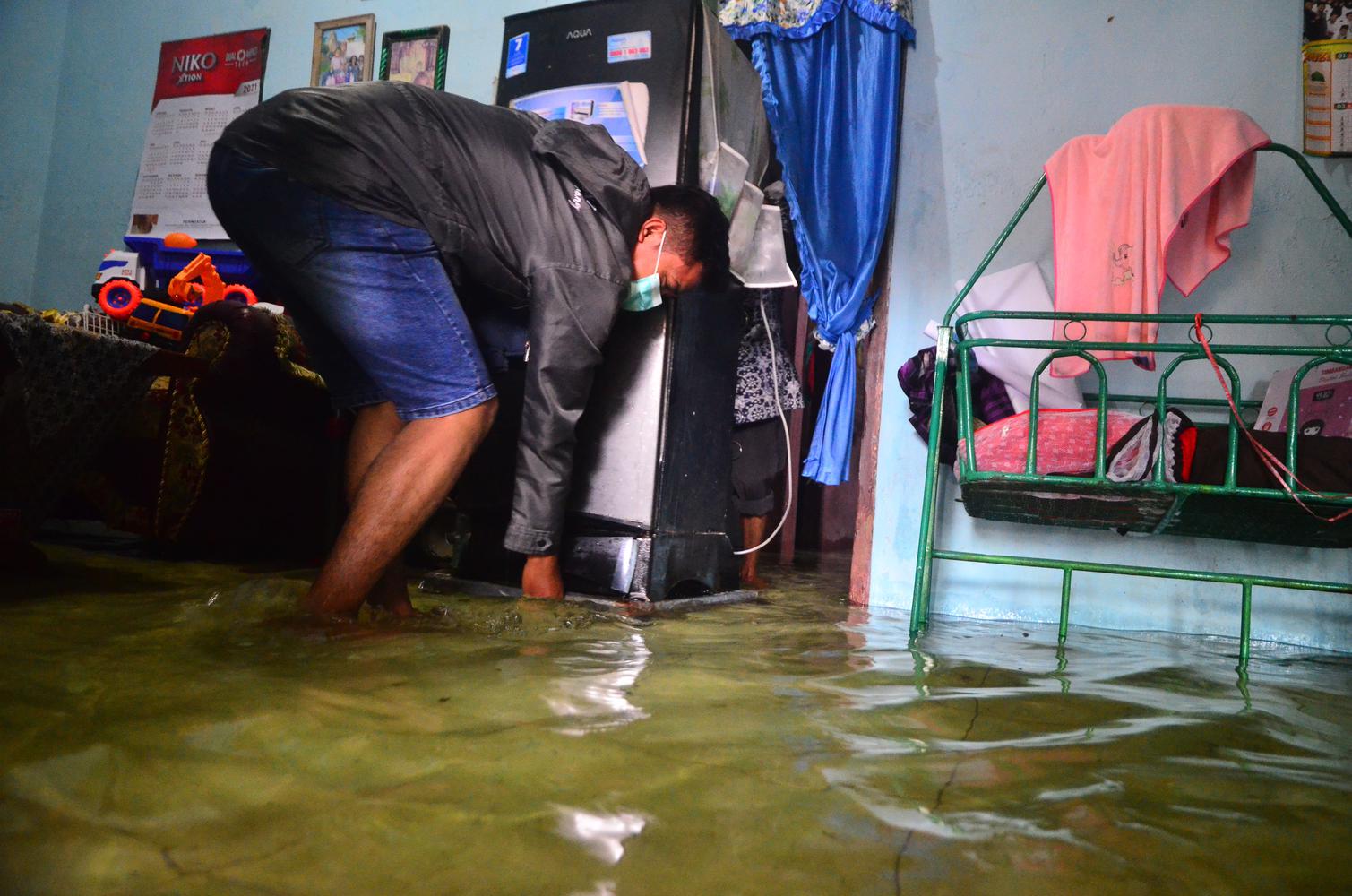 Warga menyelamatkan barang di rumah yang terendam banjir di Desa Jati Wetan, Kudus, Jawa Tengah, Kamis (10/12/2020). Akibat intensitas hujan yang tinggi sebanyak 75 rumah di wilayah itu terendam banjir dengan ketinggian 15-60 centimeter sejak dua hari terakhir.