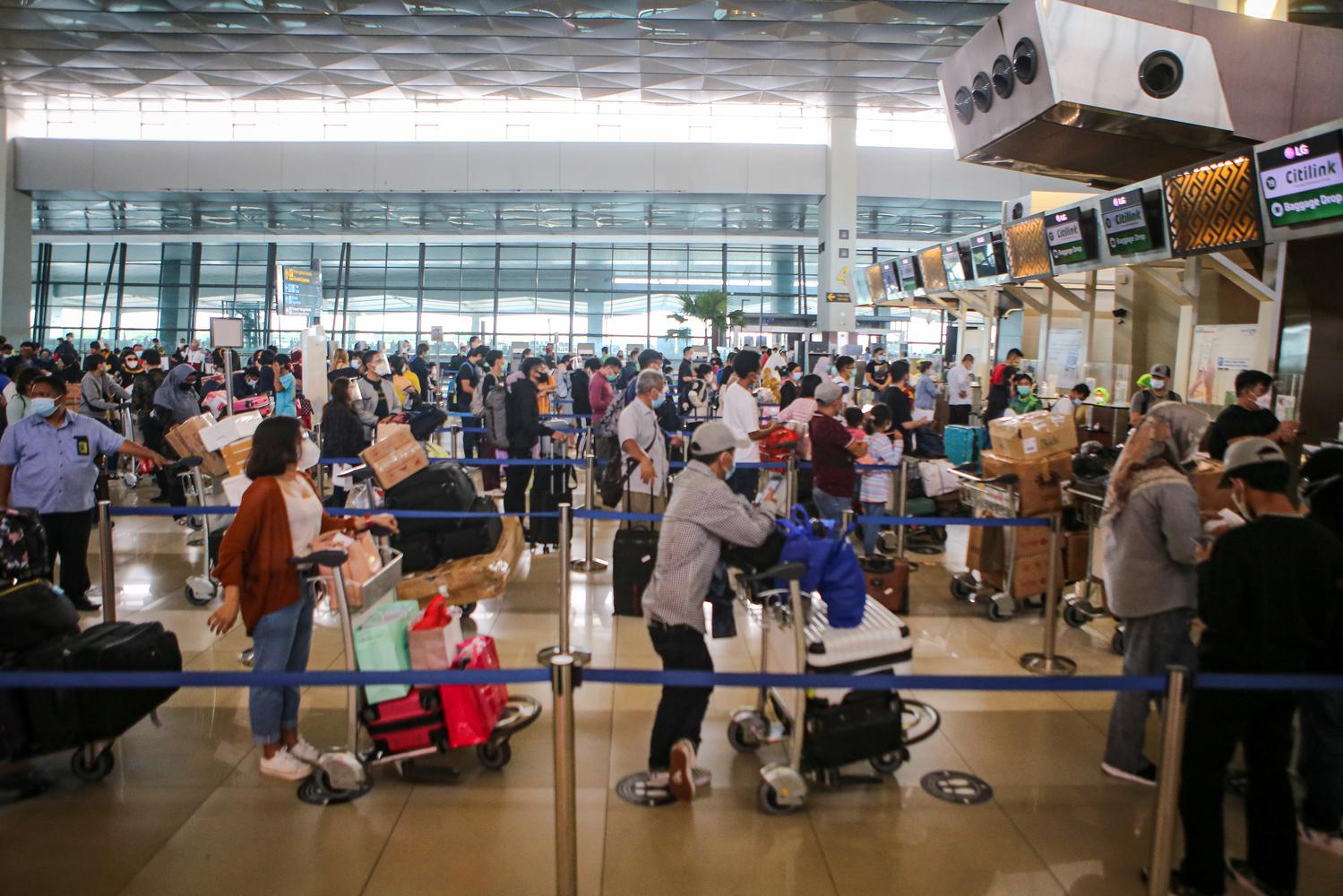 Calon penumpang mengantre untuk check in di Terminal 3 Bandara Soekarno Hatta, Tangerang, Banten, Kamis (17/12/2020). PT Angkasa Pura II memprediksi lalu lintas angkutan udara 2,1 juta penumpang pada periode angkutan Natal dan Tahun Baru 2021.