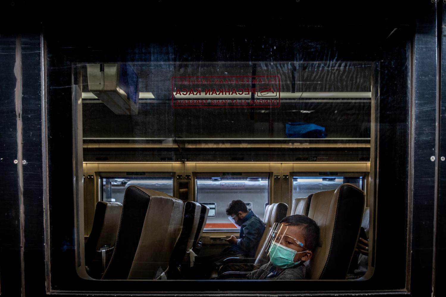 Sejumlah penumpang berada dalam rangkaian kereta api (KA) Maharani di Stasiun Tawang, Semarang, Jawa Tengah, Jumat (18/12/2020). PT KAI Daop 4 Semarang dalam menghadapi masa Angkutan Natal dan Tahun Baru 2020/2021 di tengah Pandemi Covid-19, menyiagakan berbagai fasilitas kesehatan di 12 stasiun, penerapan protokol kesehatan ketat, serta menyiagakan 16 lokomotif untuk perjalanan 56 KA jarak jauh maupun lokal.