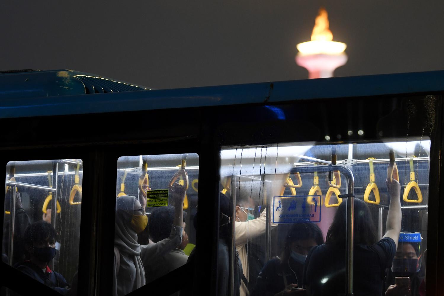 Penumpang menaiki Bus Transjakarta saat melintasi kawasan Pantung Arjuna Wiwaha, Jakarta, Rabu (6/1/2021). Pemerintah melakukan pengetatan pembatasan pergerakan di Jawa dan Bali pada 11-25 Januari 2021 untuk menekan penyebaran COVID-19, diantaranya dengan melakukan pembatasan kapasitas dan operasional transportasi umum.