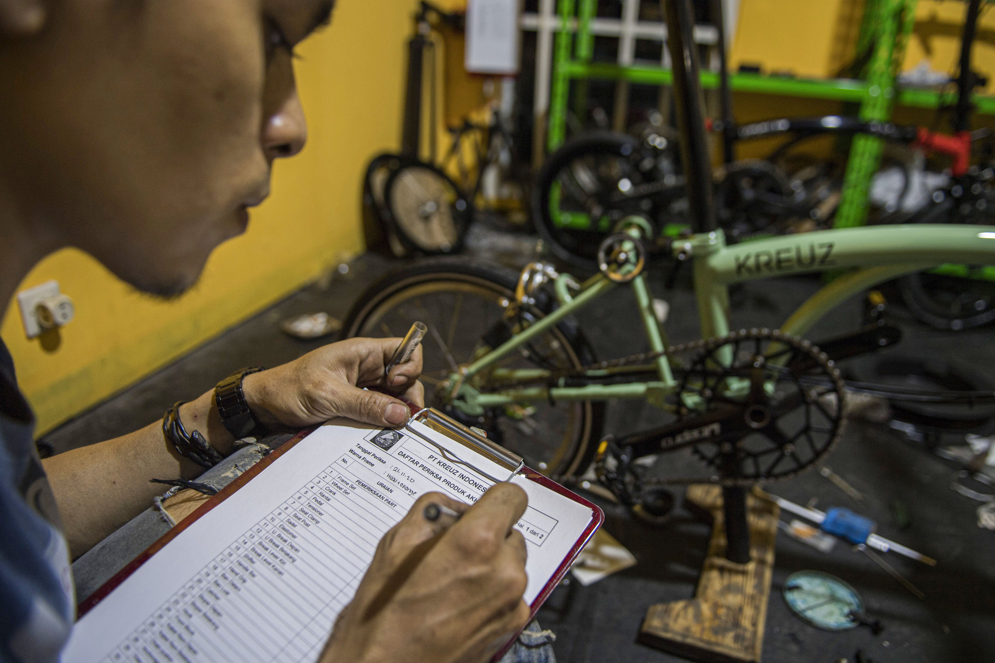 Pekerja memeriksa daftar kelengkapan produk tahap akhir seusai perakitan sepeda lipat Kreuz di Bandung, Jawa Barat, Sabtu (21/11/2020). 