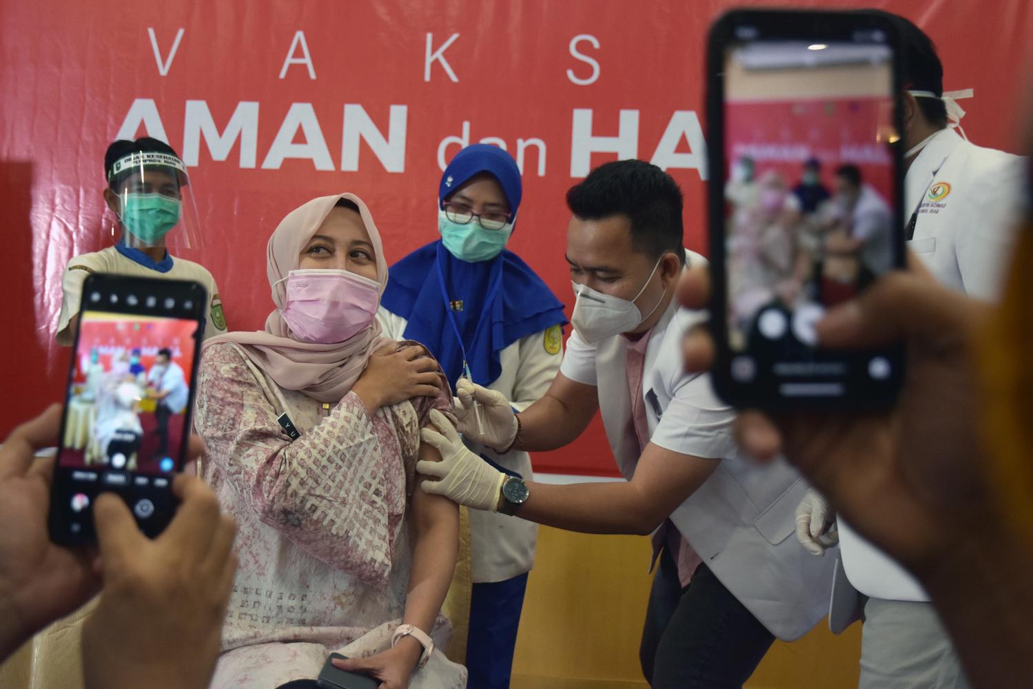 Seorang dokter (kedua kanan) menjalani vaksinasi COVID-19 di RSUD Arifin Achmad, Kota Pekanbaru, Riau, Kamis (14/1/2021). Pemerintah Provinsi Riau memastikan vaksin COVID-19 tahap awal mencukupi untuk seluruh tenaga kesehatan (Nakes) sebanyak 35.985 orang, yang menjadi sasaran prioritas vaksinasi tahap pertama pada tahun ini.