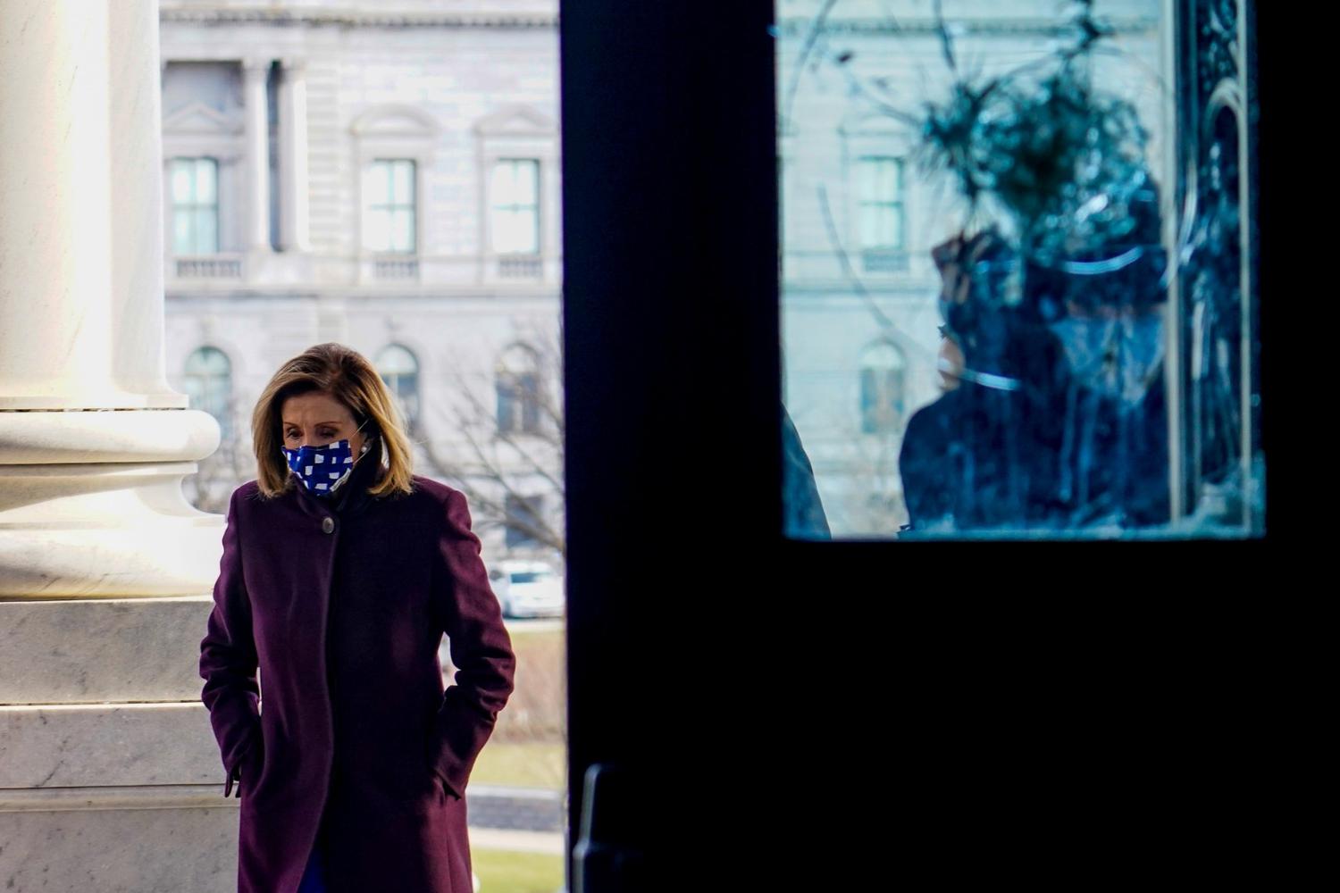 Erin Scott Ketua Dewan Perwakilan Rakyat AS Nancy Pelosi (D-CA) berdiri dekat sebuah pintu yang rusak oleh perusuh yang menyerbu masuk gedung Capitol, saat ia berpartisipasi dalam acara pelantikan di Capitol di Washington, Amerika Serikat, Selasa (19/1/2021).