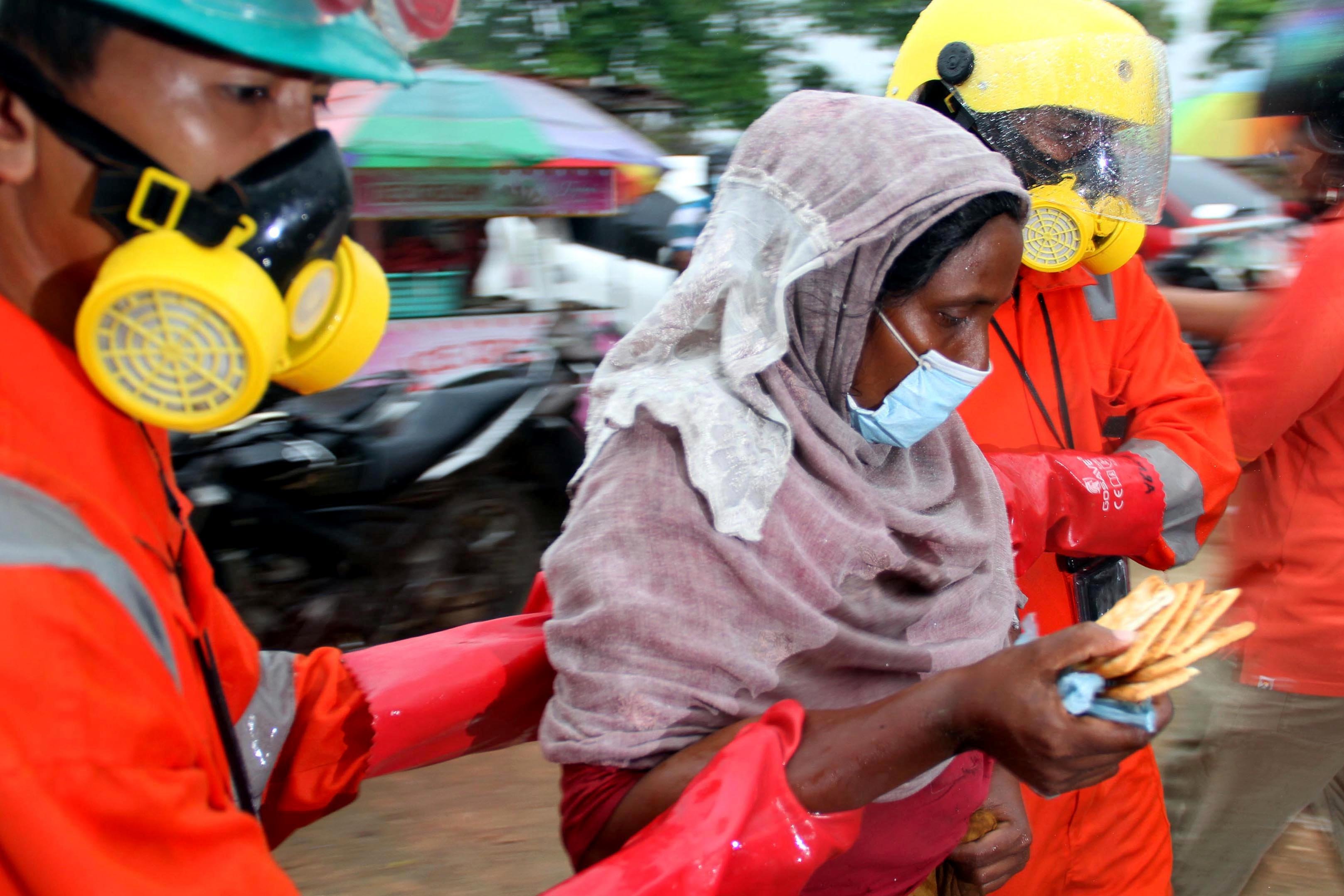 Petugas BPBD membantu pengungsi etnis Rohingya yang sakit usai dievakuasi di pesisir pantai Syantalira Bayu, Aceh Utara, Aceh. \r\n