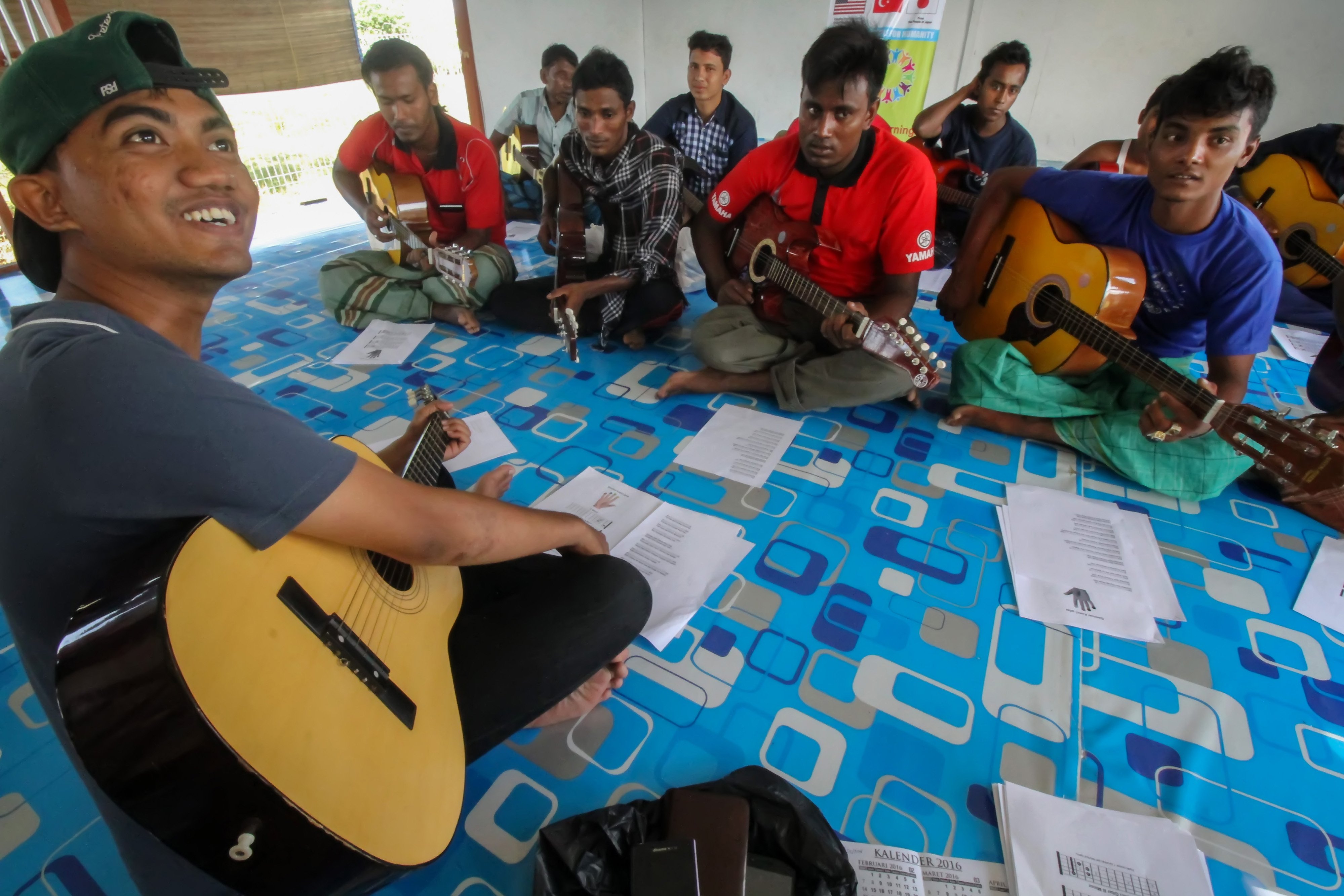 Sejumlah pengungsi etnis Rohingya mendapatkan pelatihan bermain gitar di tempat penampungan Desa Blang Adoe, Aceh Utara, Aceh.