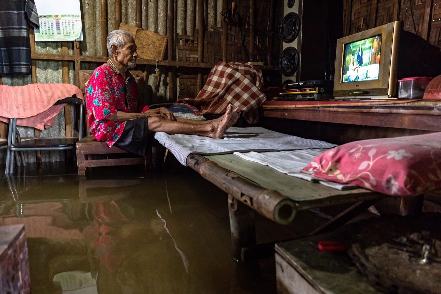 Warga menyaksikan tayangan televisi di dalam rumahnya yang terendam banjir di Desa Sayung, Kecamatan Sayung, Kabupaten Demak, Jawa Tengah, Minggu (7/2/2021). Berdasarkan data dari Kantor Balai Desa Sayung, sebanyak 3.161 keluarga dengan total 10.297 jiwa yang tersebar di delapan dukuh di desa tersebut terendam banjir dengan variasi ketinggian sekitar 40-120 cm disebabkan oleh curah hujan tinggi serta meluapnya Sungai Dombo Sayung.