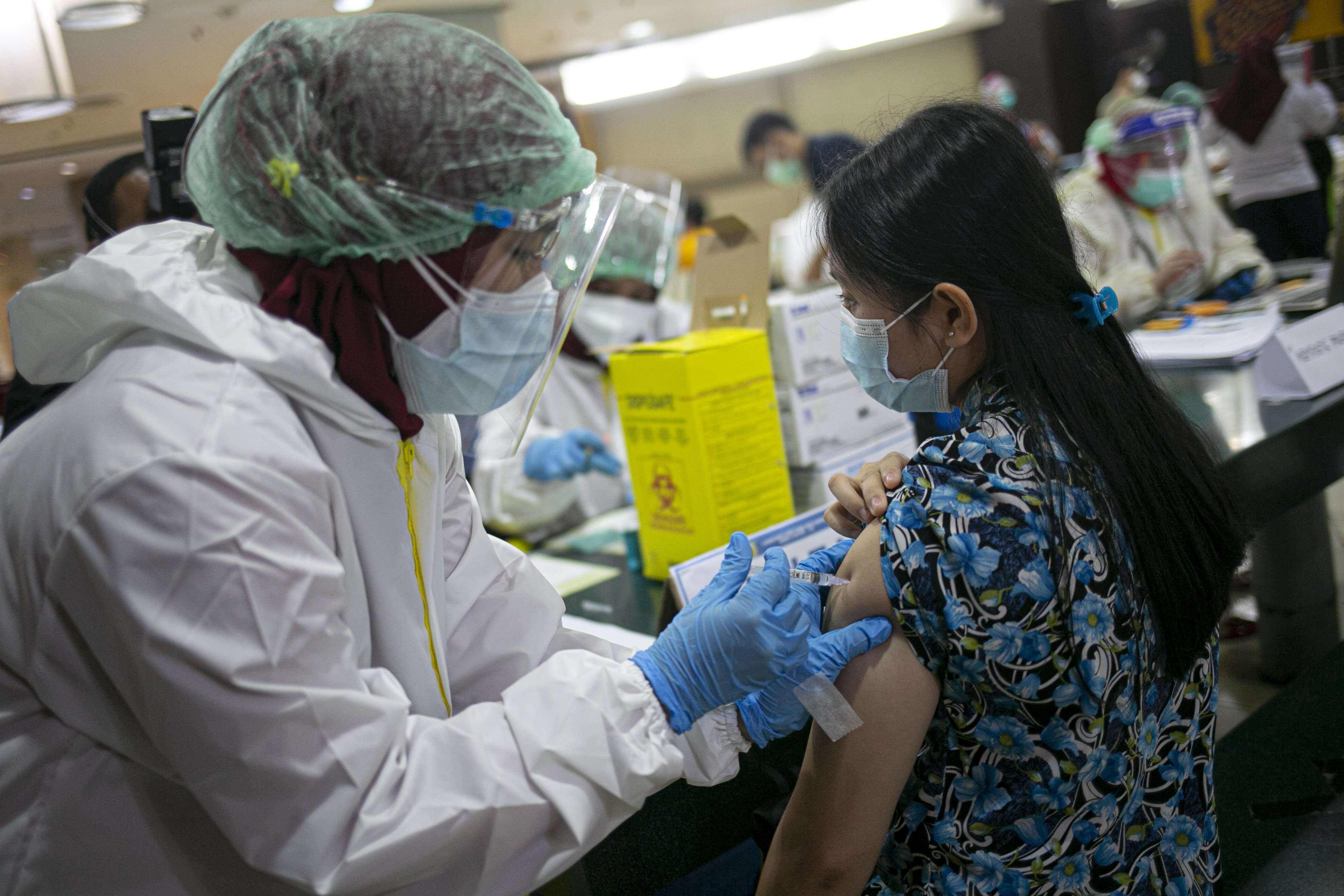 Petugas medis menyuntikan vaksin covid-19 kepada pedagang di Pasar Tanah Abang Blok A, Jakarta, Rabu (17/2/2021). Vaksinasi covid-19 tahap kedua yang diberikan untuk pekerja publik dan lansia itu dimulai dari pedagang Pasar Tanah Abang.