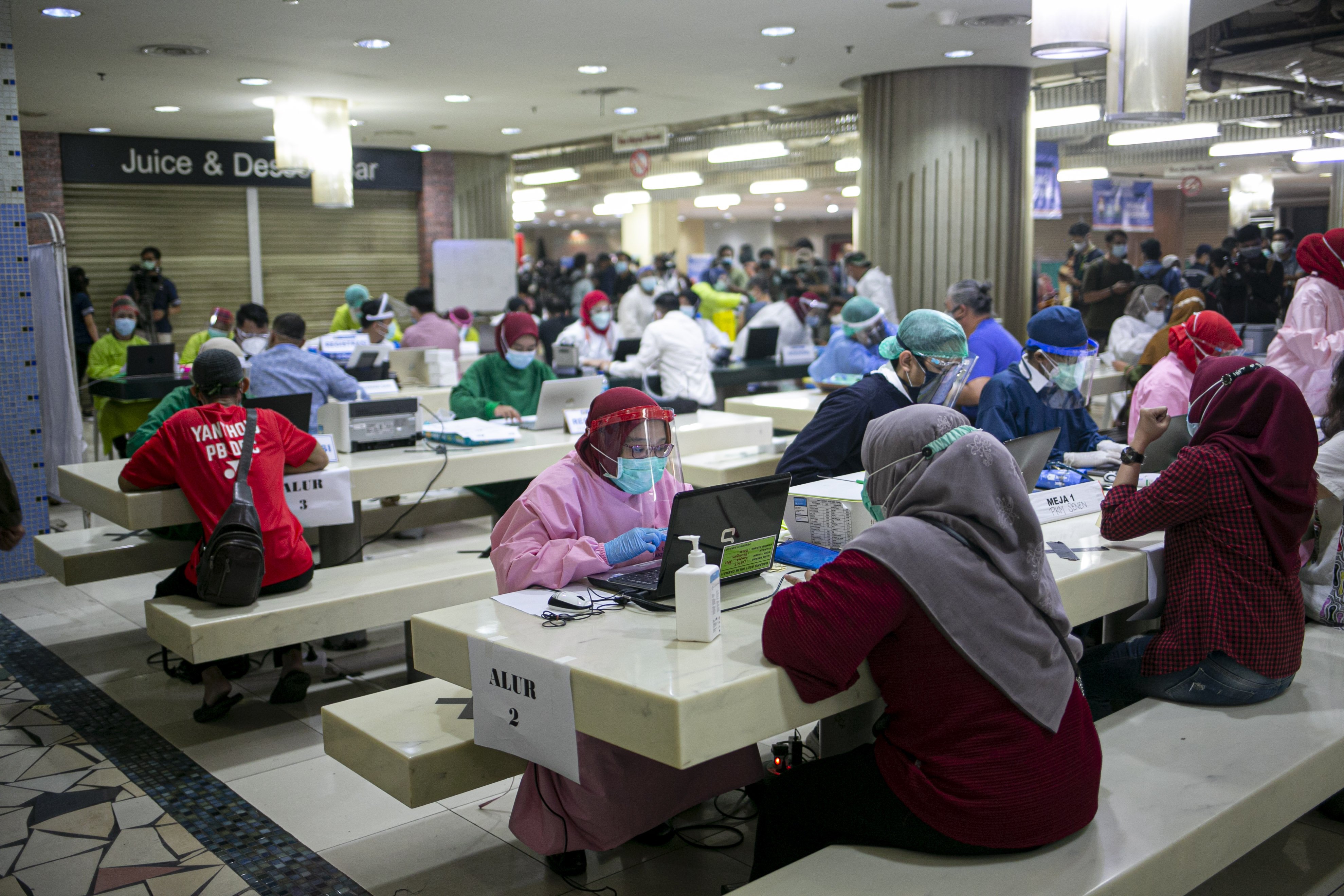 Petugas vaksinasi memeriksa kesehatan pedagang sebelum disuntik vaksin COVID-19 di Pasar Tanah Abang Blok A, Jakarta, Rabu (17/2/2021). Vaksinasi covid-19 tahap kedua yang diberikan untuk pekerja publik dan lansia itu dimulai dari pedagang Pasar Tanah Abang.