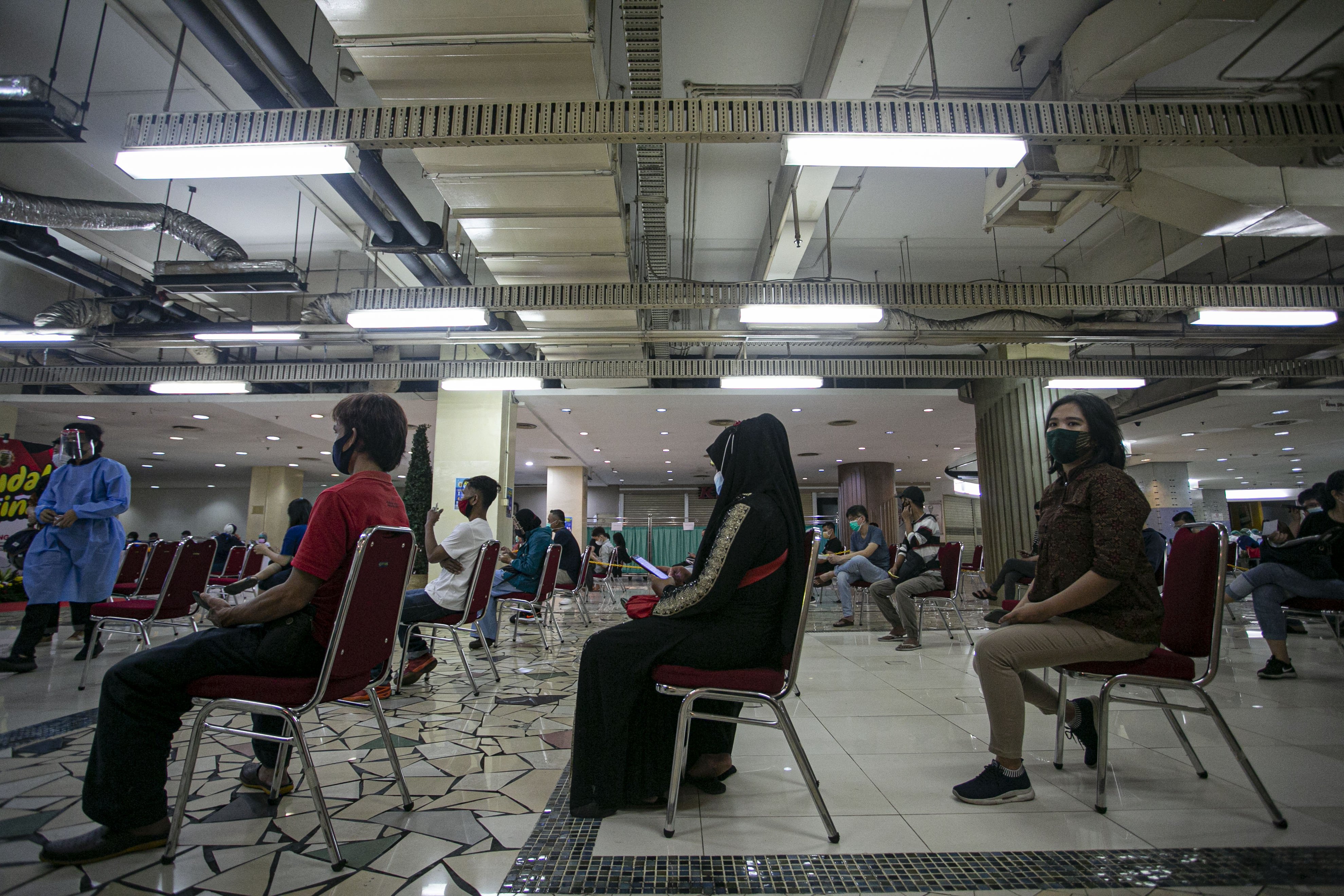 Sejumlah pedagang menunggu giliran vaksinasi covid-19 di Pasar Tanah Abang Blok A, Jakarta, Rabu (17/2/2021). Vaksinasi covid-19 tahap kedua yang diberikan untuk pekerja publik dan lansia itu dimulai dari pedagang Pasar Tanah Abang.