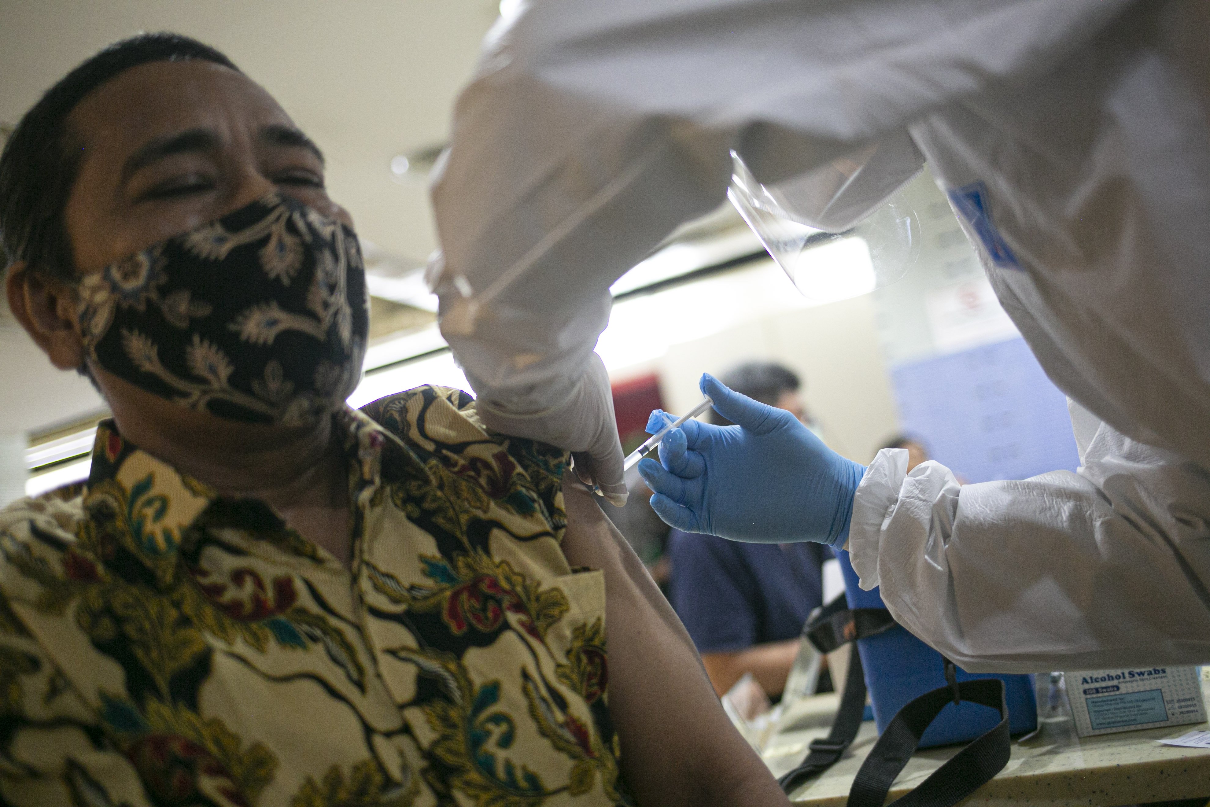 Petugas medis menyuntikan vaksin covid-19 kepada pedagang di Pasar Tanah Abang Blok A, Jakarta, Rabu (17/2/2021). Vaksinasi covid-19 tahap kedua yang diberikan untuk pekerja publik dan lansia itu dimulai dari pedagang Pasar Tanah Abang.