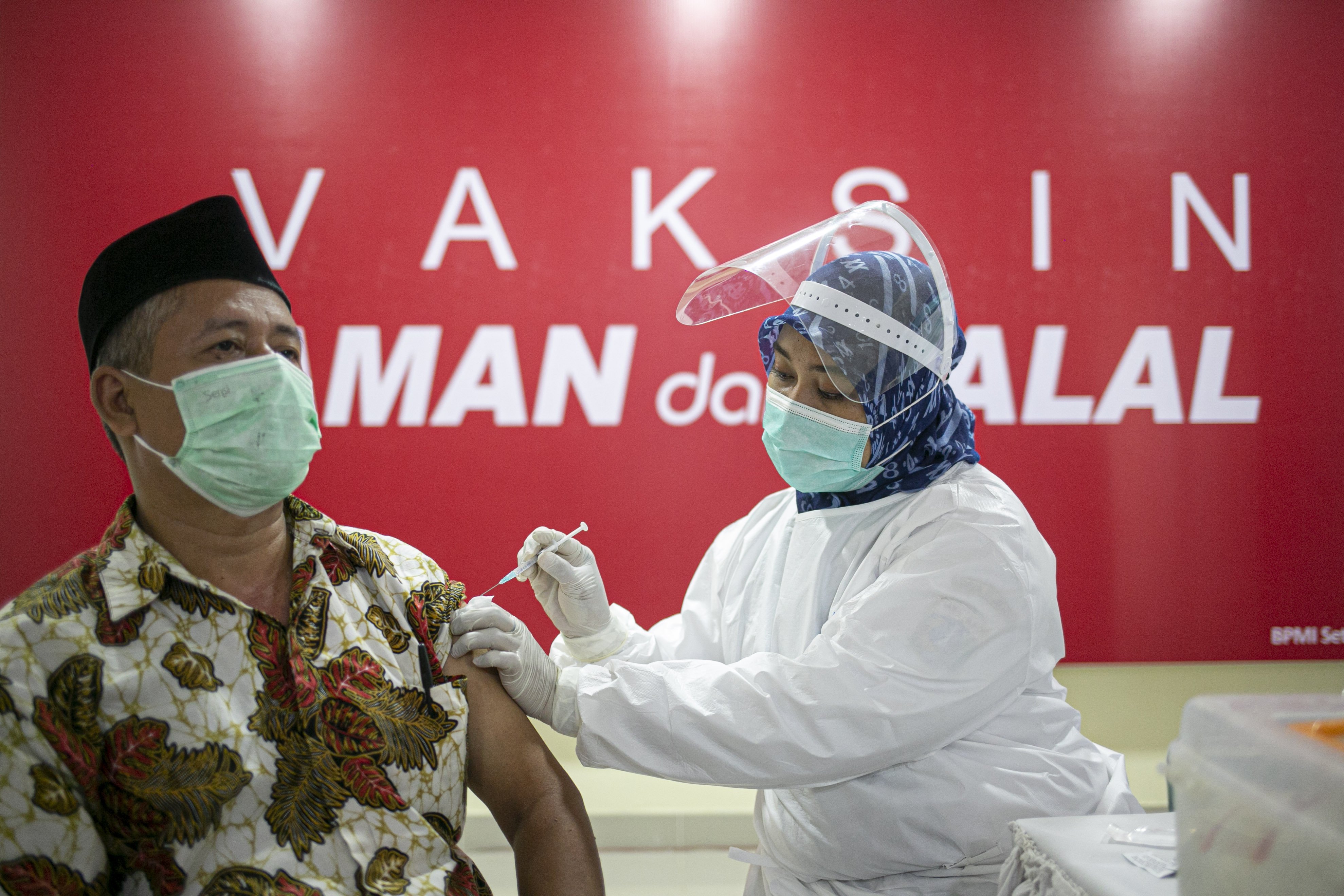 Petugas menyuntikkan vaksin COVID-19 kepada tenaga pengajar dalam acara vaksinasi massal di SMA Negeri 70 Jakarta, Jakarta, Rabu (24/2/2021). Pemerintah memulai tahap vaksinasi untuk guru, tenaga kependidikan, dan dosen dengan target sebanyak 5.057.582 orang se-Indonesia.