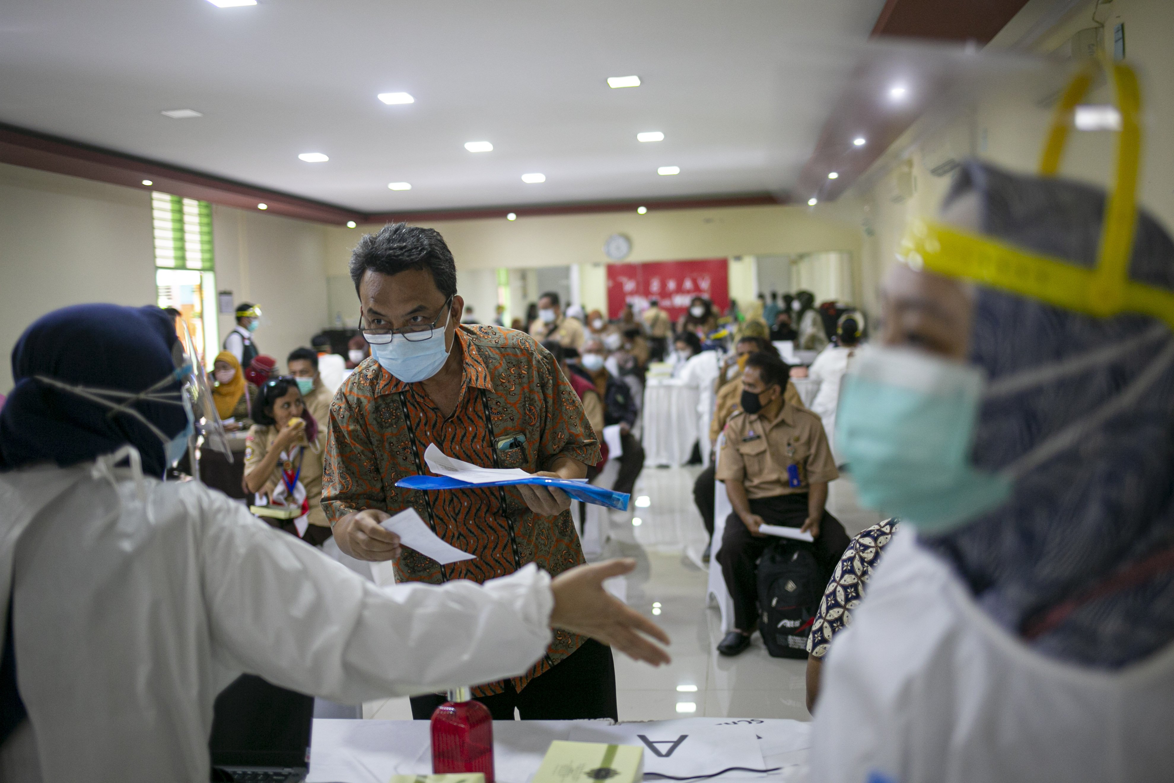 Petugas melakukan pemeriksaan awal kepada tenaga pendidik sebelum vaksinasi COVID-19 di SMA Negeri 70 Jakarta, Jakarta, Rabu (24/2/2021). Pemerintah memulai tahap vaksinasi untuk guru, tenaga kependidikan, dan dosen dengan target sebanyak 5.057.582 orang se-Indonesia.