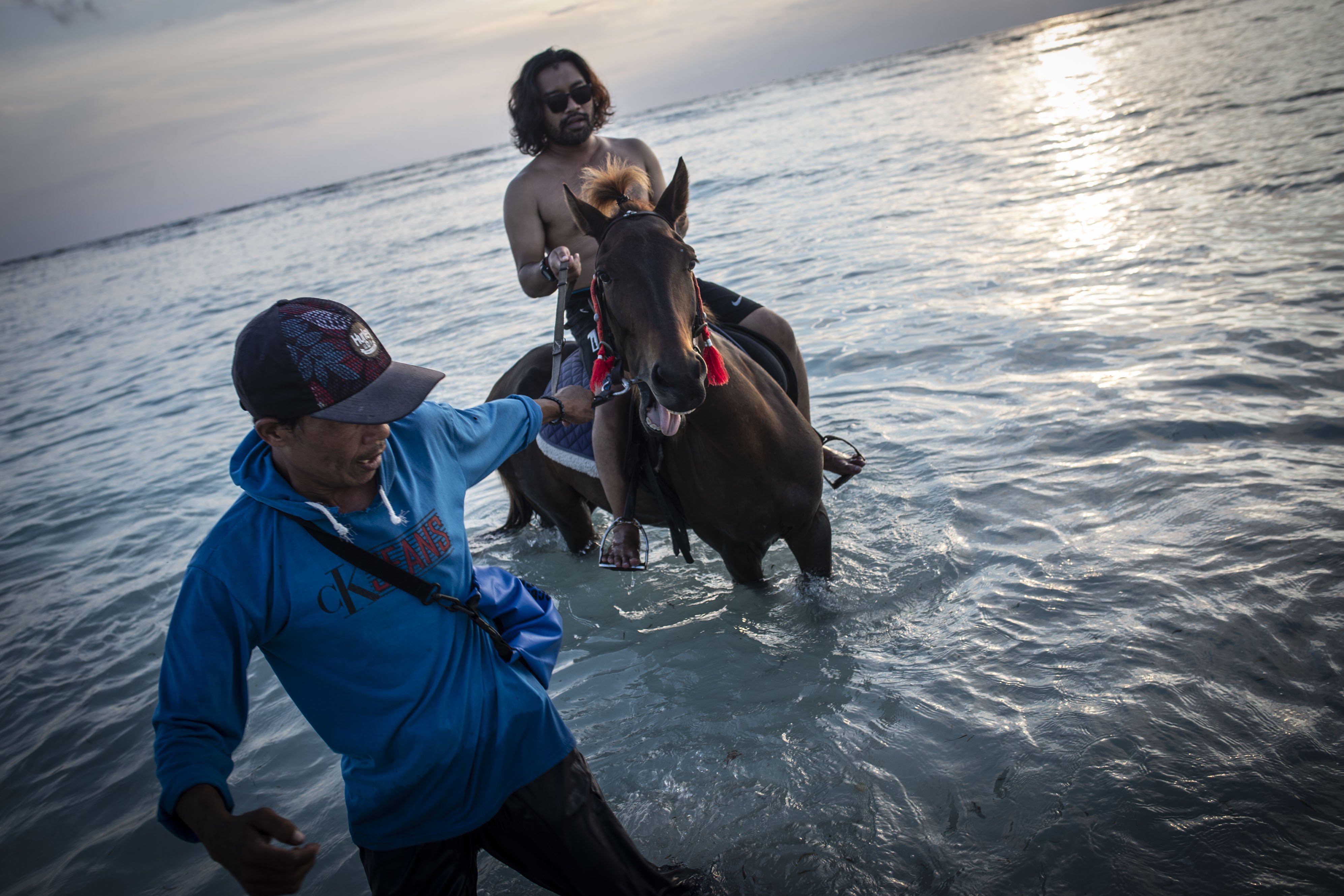 Wisatawan menaiki kuda di tepi pantai di Gili Trawangan, Kepulauan Gili, Lombok Utara, Nusa Tenggara Barat, Sabtu (6/3/2021). Kepulauan Gili merupakan salah satu destinasi wisata keunggulan Lombok yang terdiri dari tiga pulau, yaitu Gili Trawangan, Meno, dan Air. 