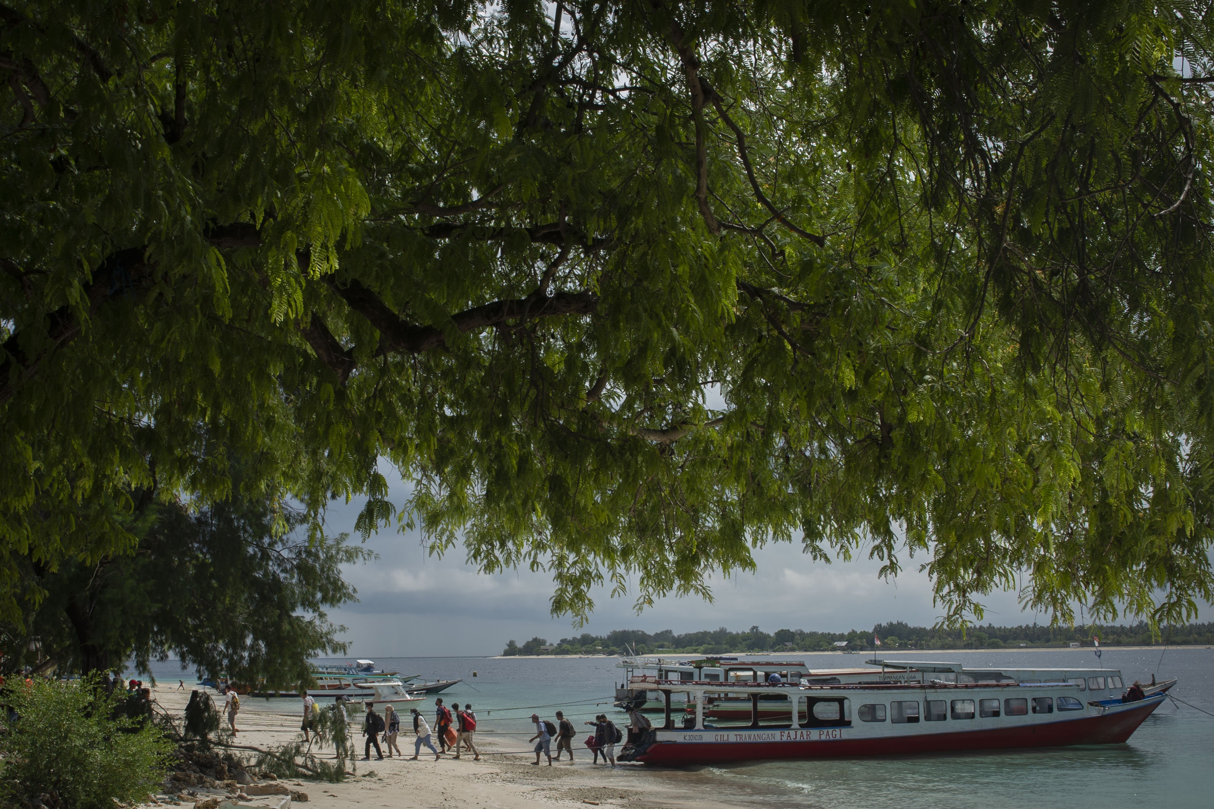 Warga setempat dan wisatawan turun dari kapal di Gili Trawangan, Kepulauan Gili, Lombok Utara, Nusa Tenggara Barat, Sabtu (6/3/2021). Kepulauan Gili merupakan salah satu destinasi wisata keunggulan Lombok yang terdiri dari tiga pulau, yaitu Gili Trawangan, Meno, dan Air. 