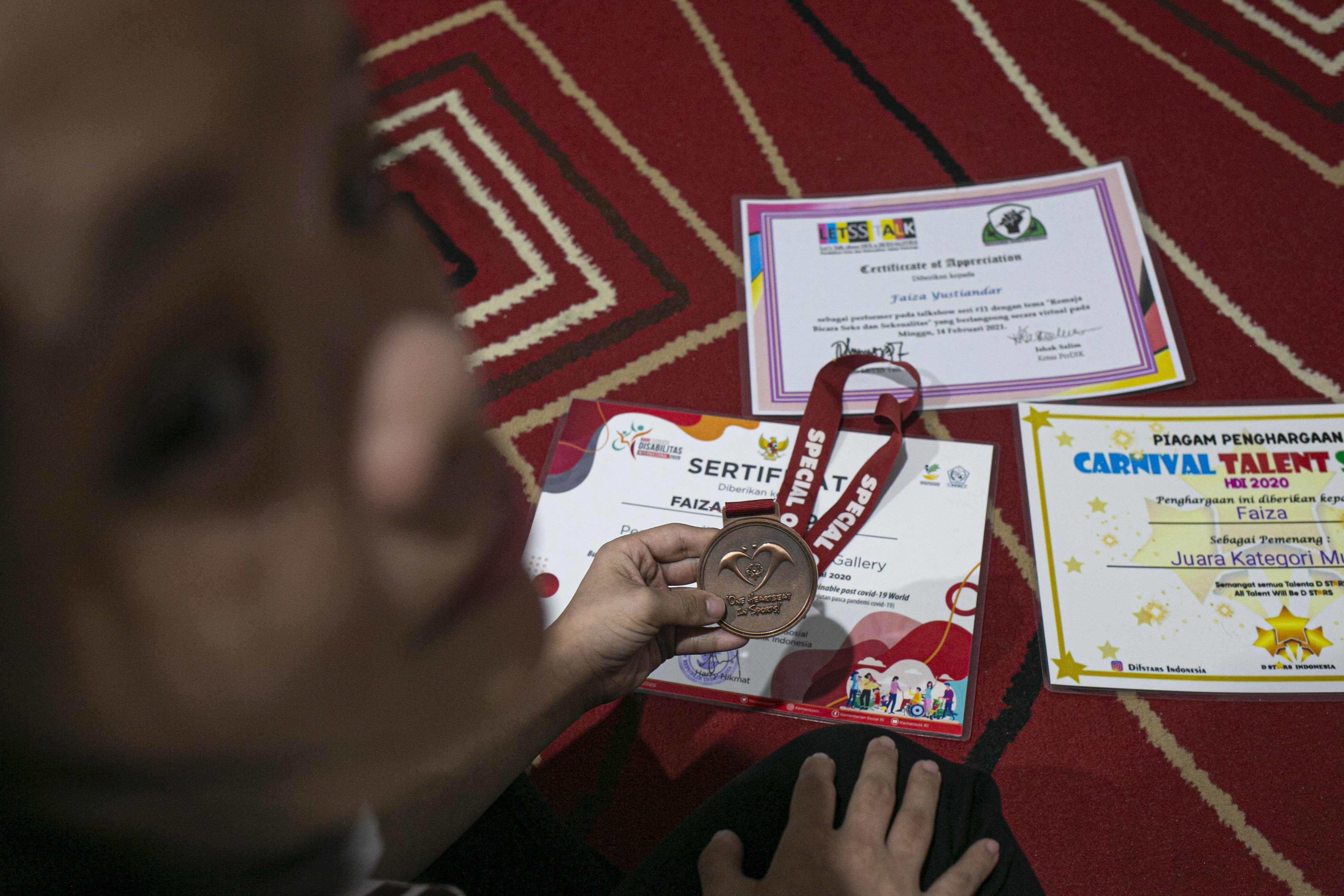 Faiza Yustiandari memperlihatkan sejumlah sertifikat dan medali atas prestasinya di bidang seni.