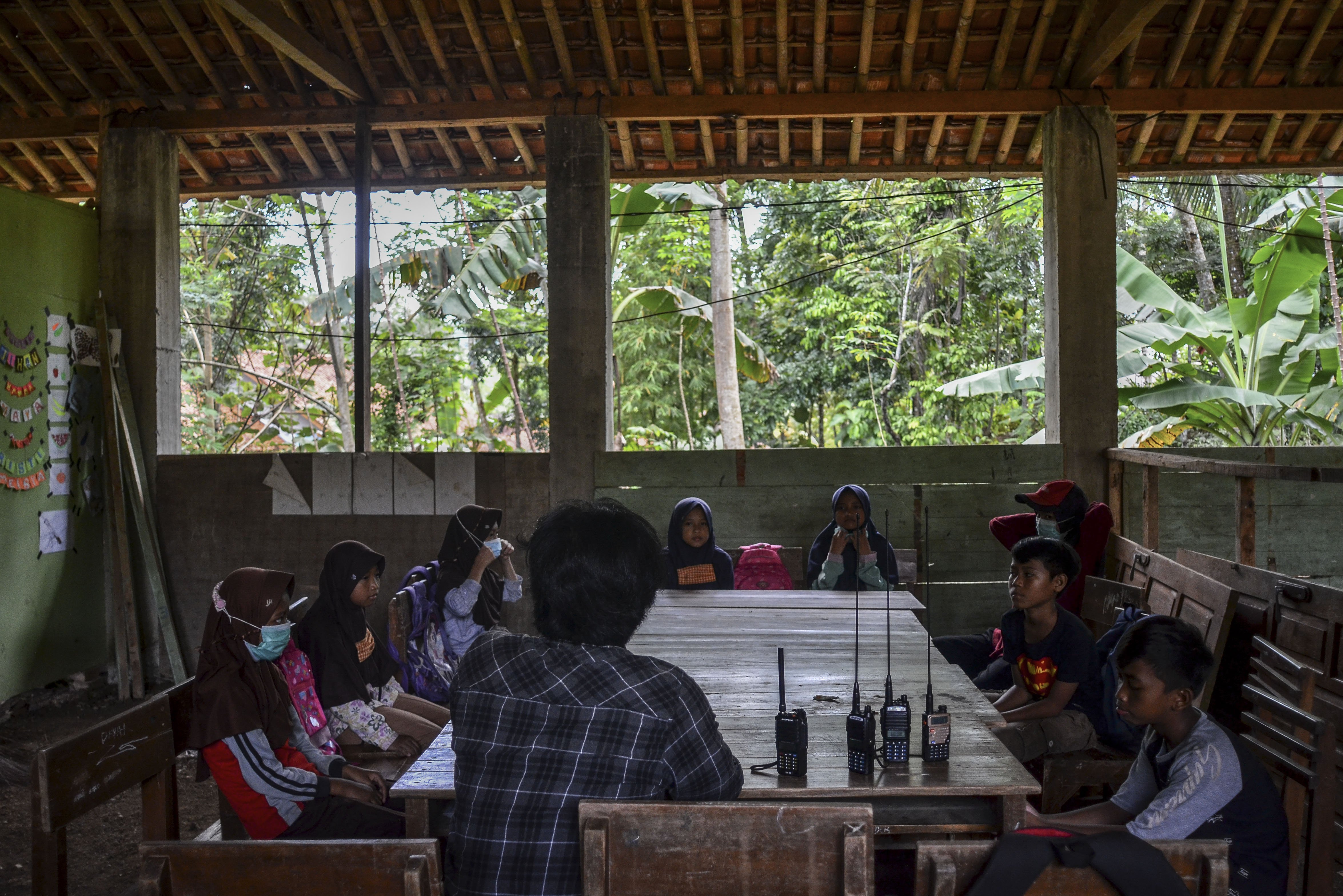 Siswa sekolah Madrasah Ibtidaiyah Pesawahan belajar cara mengoperasikan radio Handy Talky (HT) untuk pembelajaran jarak jauh di Dusun Ciakar, Desa Pasawahan, Kecamatan Banjaranyar Kabupaten Ciamis, Jawa Barat.