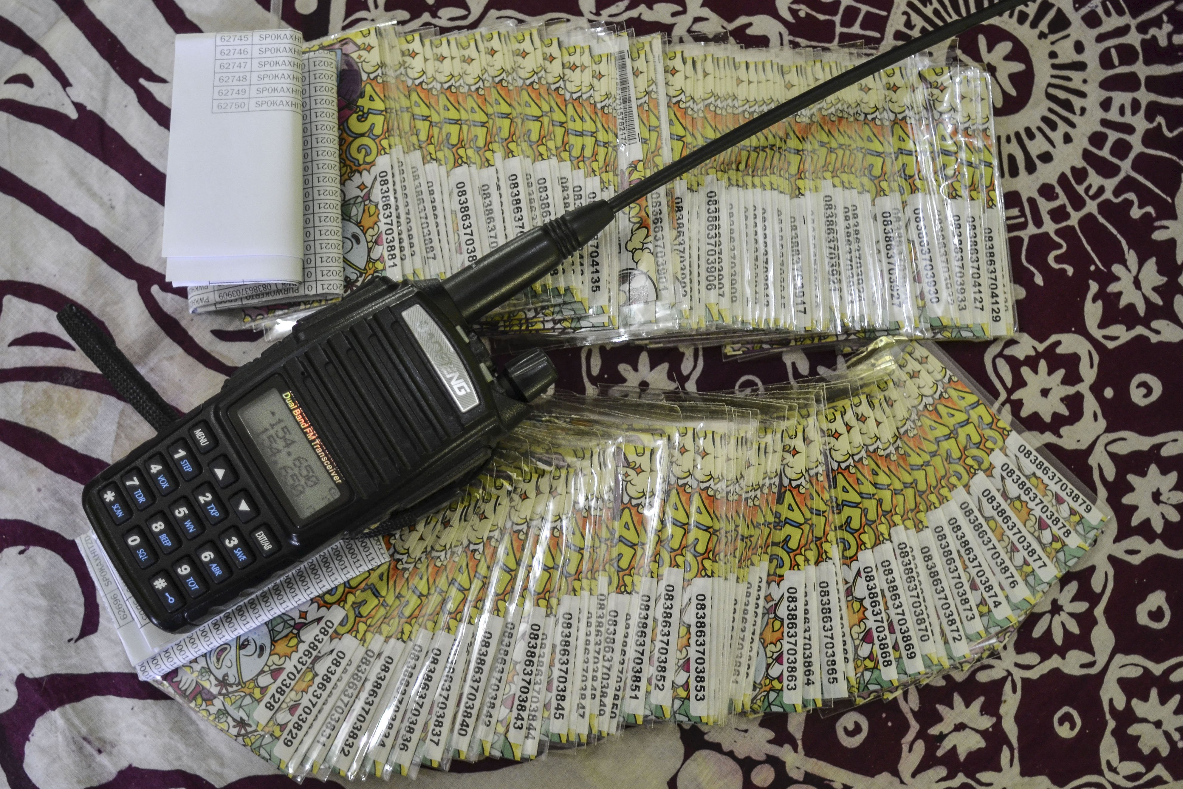 Tumpukan kartu perdana seluler bantuan dari pemerintah yang tidak terpakai dan radio Handy Talky (HT) di ruang guru sekolah Madrasah Ibtidaiyah Pasawahan, Dusun Ciakar, Desa Pasawahan, Kecamatan Banjaranyar Kabupaten Ciamis, Jawa Barat.