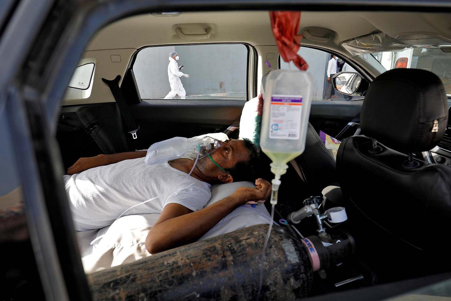 Amit Dave Seorang pasien dengan gangguan pernapa berbaring di dalam mobil bil menunggu untuk masuk rumah it COVID-19 untuk perawatan, di tengah penyebaran penyakit virus corona (COVID-19), di Ahmedabad, India, Kamis (22/4/2021).