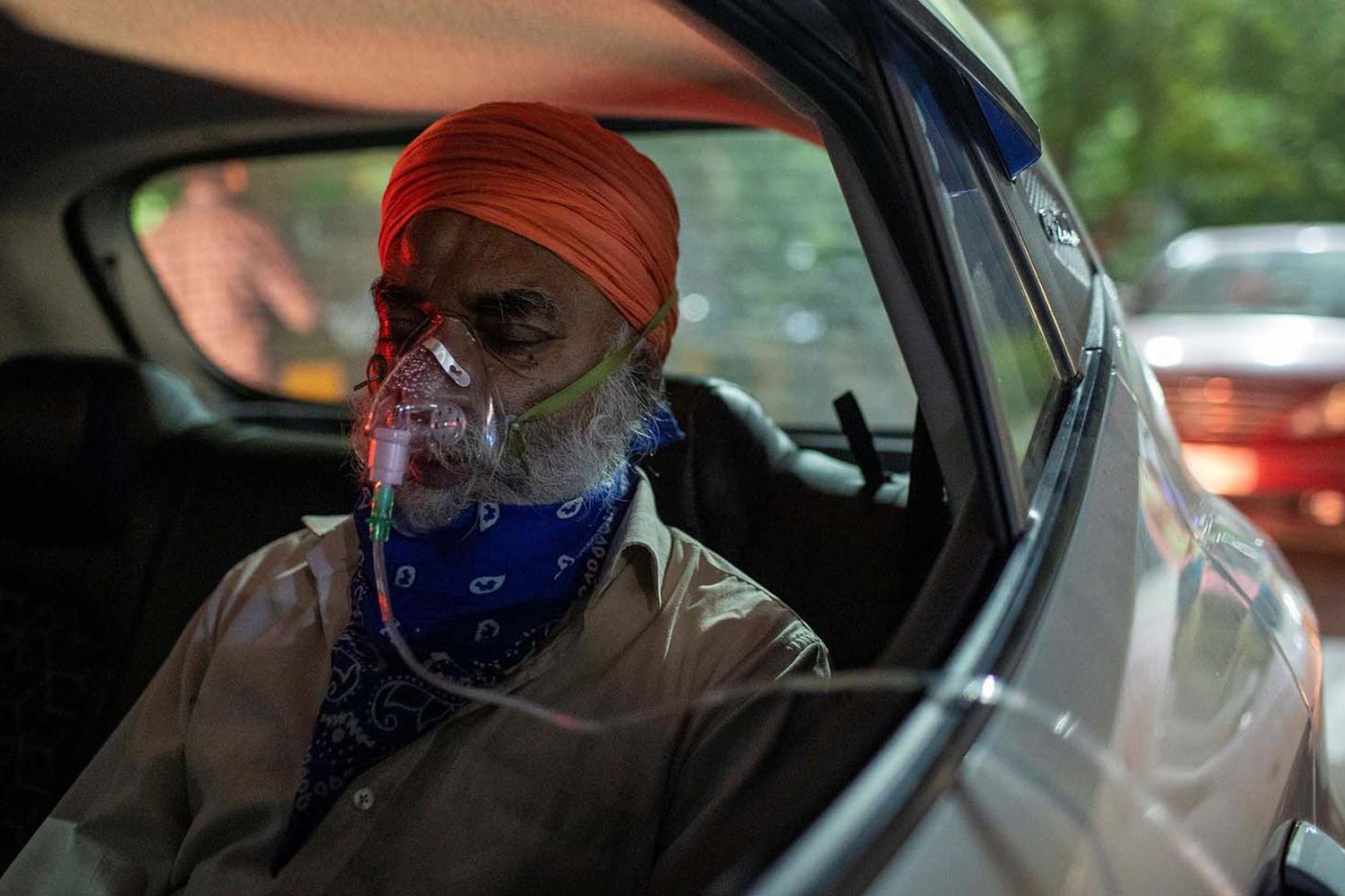 Danish Siddiqui Seorang pria dengan masalah pernapasan menerima bantuan oksigen secara gratis di mobilnya di Gurudwara (kuil Sikh), ditengah mewabahnya virus corona (COVID-19), di Ghaziabad, India, Sabtu (24/4/2021).