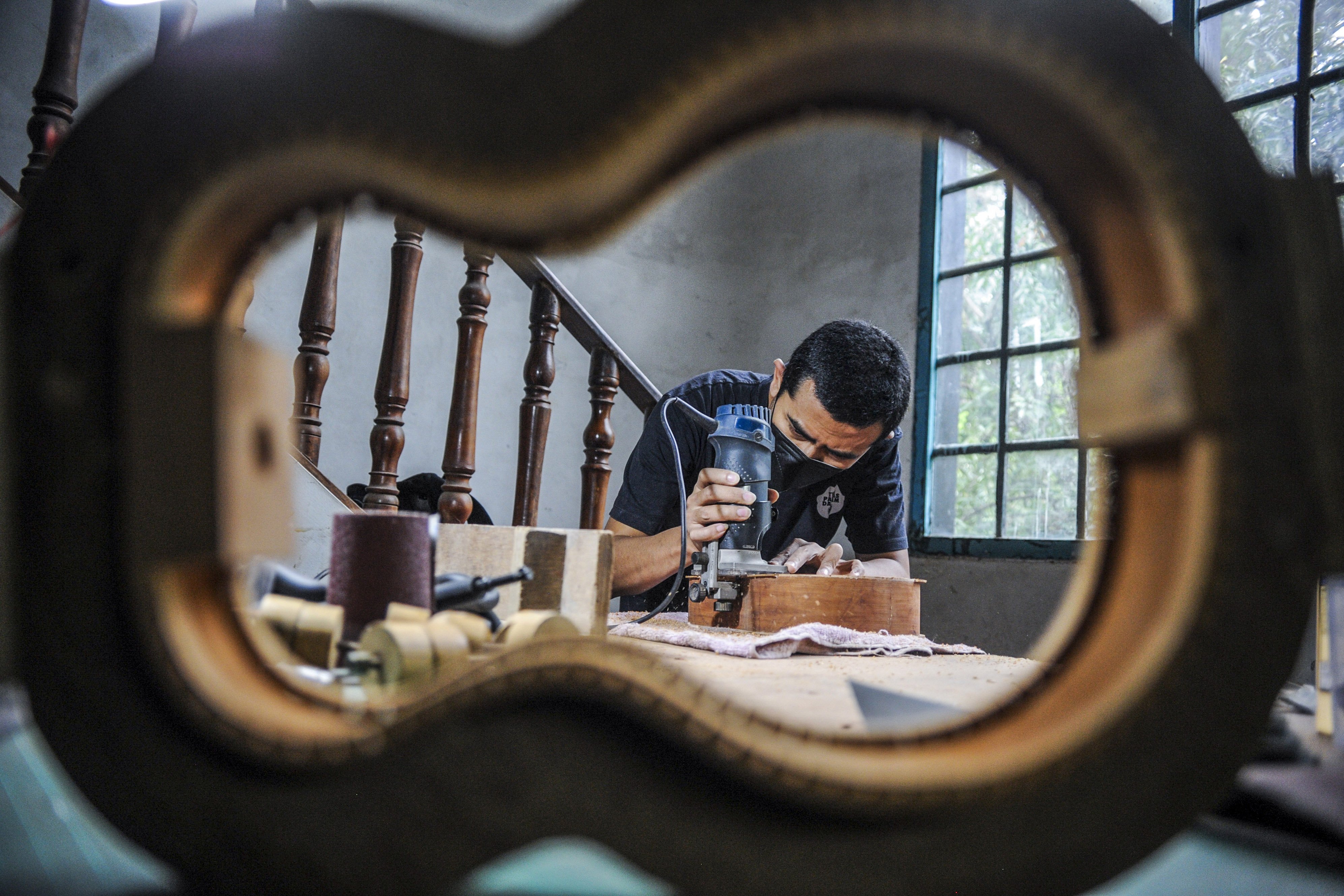 Andy Mahardika menyelesaikan pesanan ukulele di rumah produksi, Bandung, Jawa Barat.