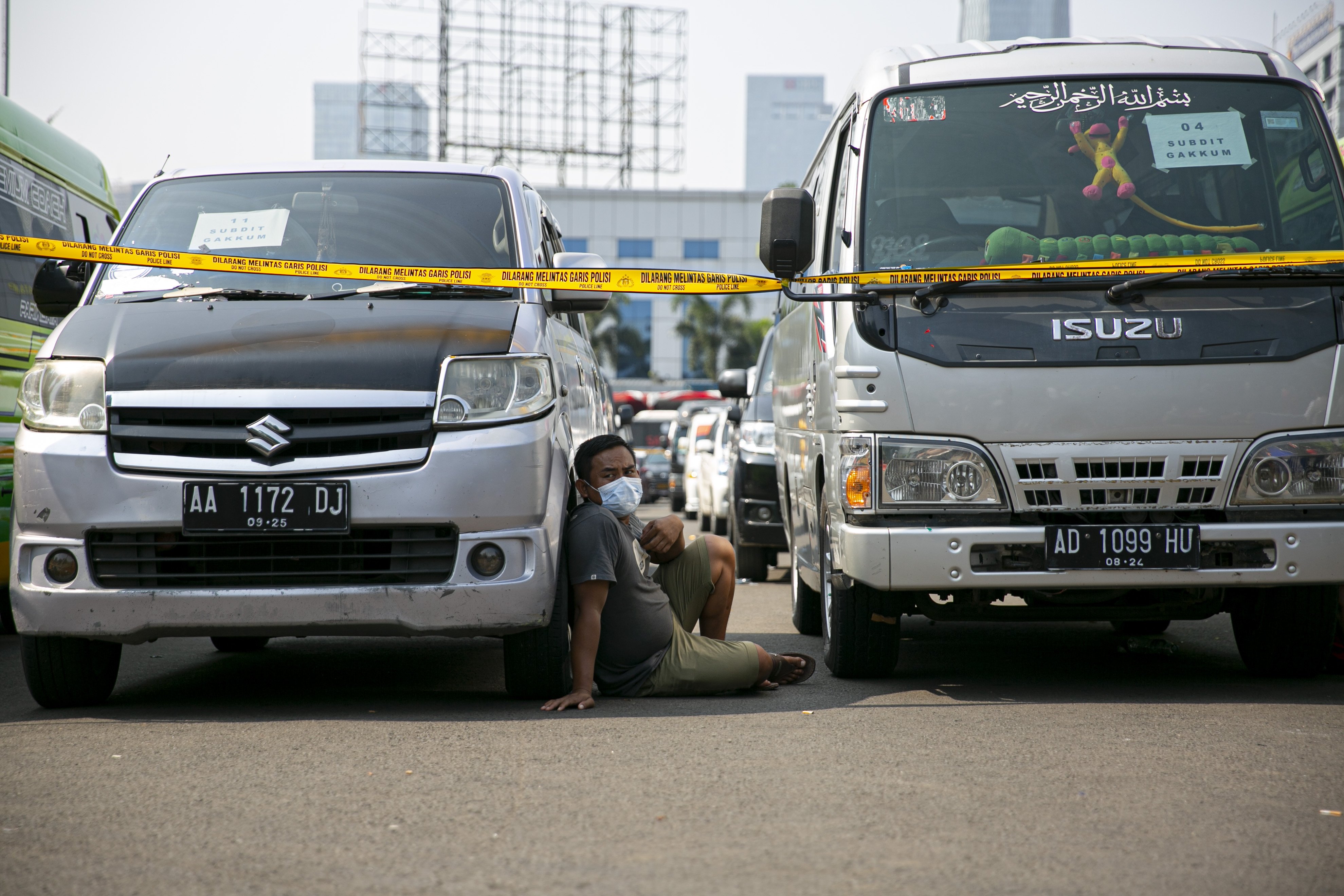 Pemilik kendaraan travel gelap menunggu hasil pemeriksaan usai diamankan petugas kepolisian di Lapangan Presisi Dit Lantas PMJ, Jakarta, Kamis (29/4/2021). Dit Lantas PMJ berhasil menangkap dan menyita sebanyak 115 kendaraan travel gelap yang beroperasi di wilayah Jakarta dan sekitarnya.