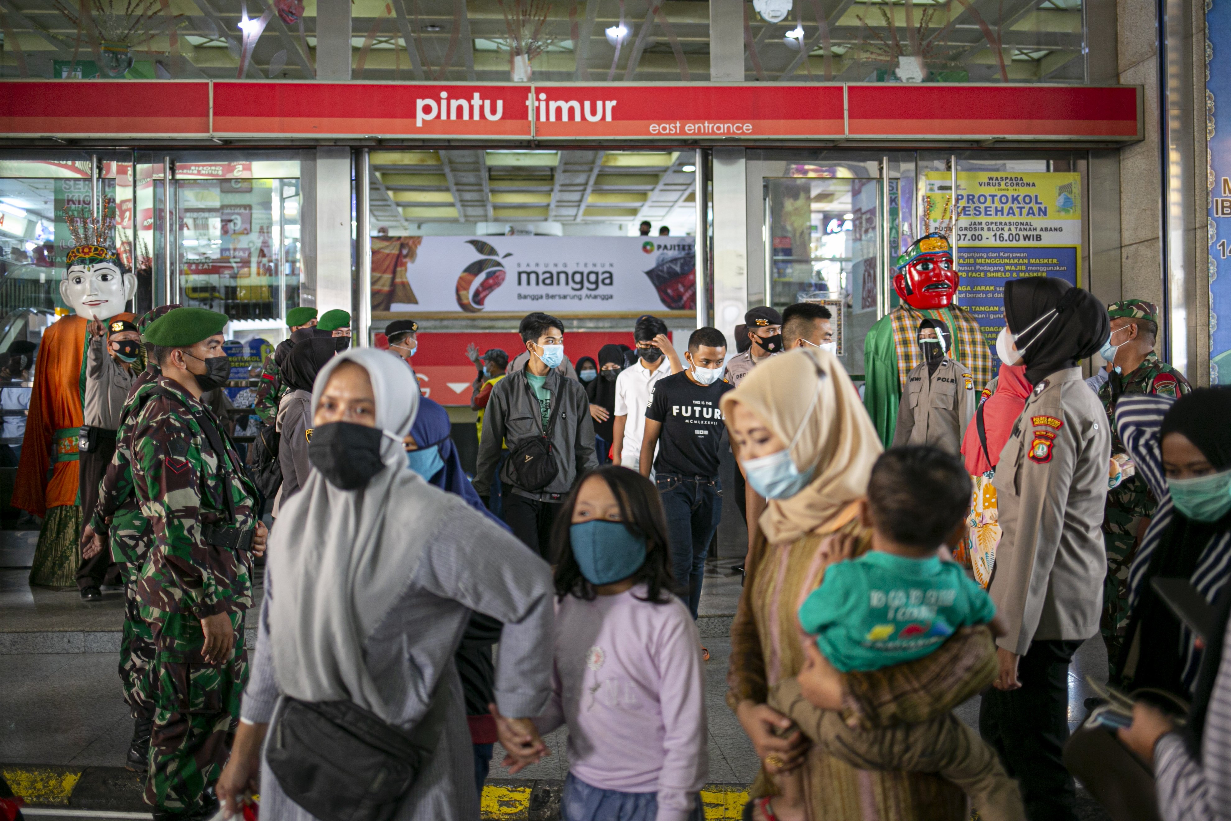Sejumlah petugas tengah menjaga pintu masuk Pasar Tanah Abang Blok A, Jakarta Pusat, Minggu (2/5/2021). H-10 menjelang Hari Raya Idul Fitri 1442 Hijriah kawasan tersebut mulai dipadati warga untuk berbelanja berbagai kebutuhan, guna mengantisipasi kepadatan petugas mengatur keluar masuk pengunjung.