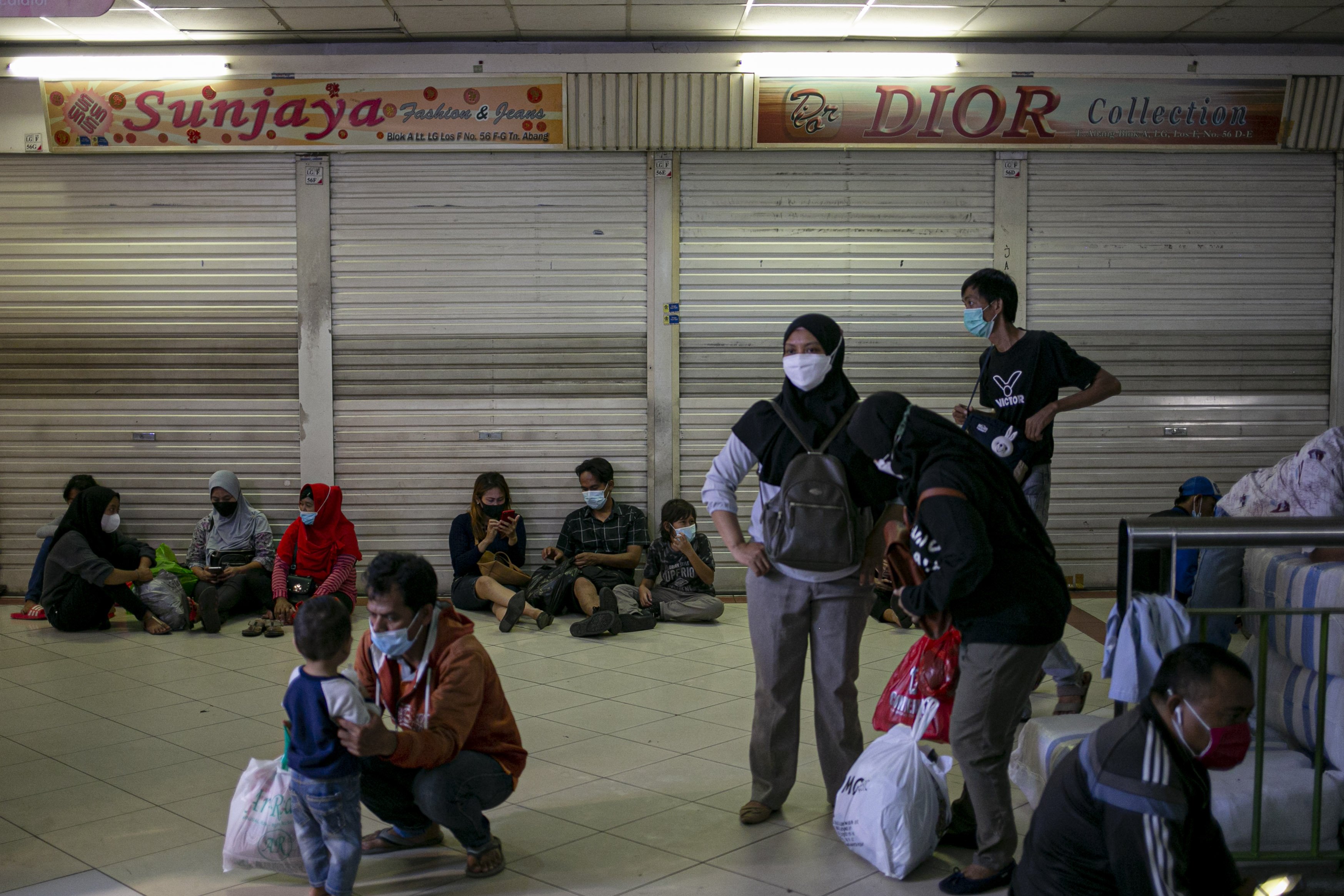 Sejumlah warga beristirahat di Pasar Tanah Abang Blok A, Jakarta Pusat, Minggu (2/5/2021). H-10 menjelang Hari Raya Idul Fitri 1442 Hijriah kawasan tersebut mulai dipadati warga untuk berbelanja berbagai kebutuhan, guna mengantisipasi kepadatan petugas mengatur keluar masuk pengunjung.