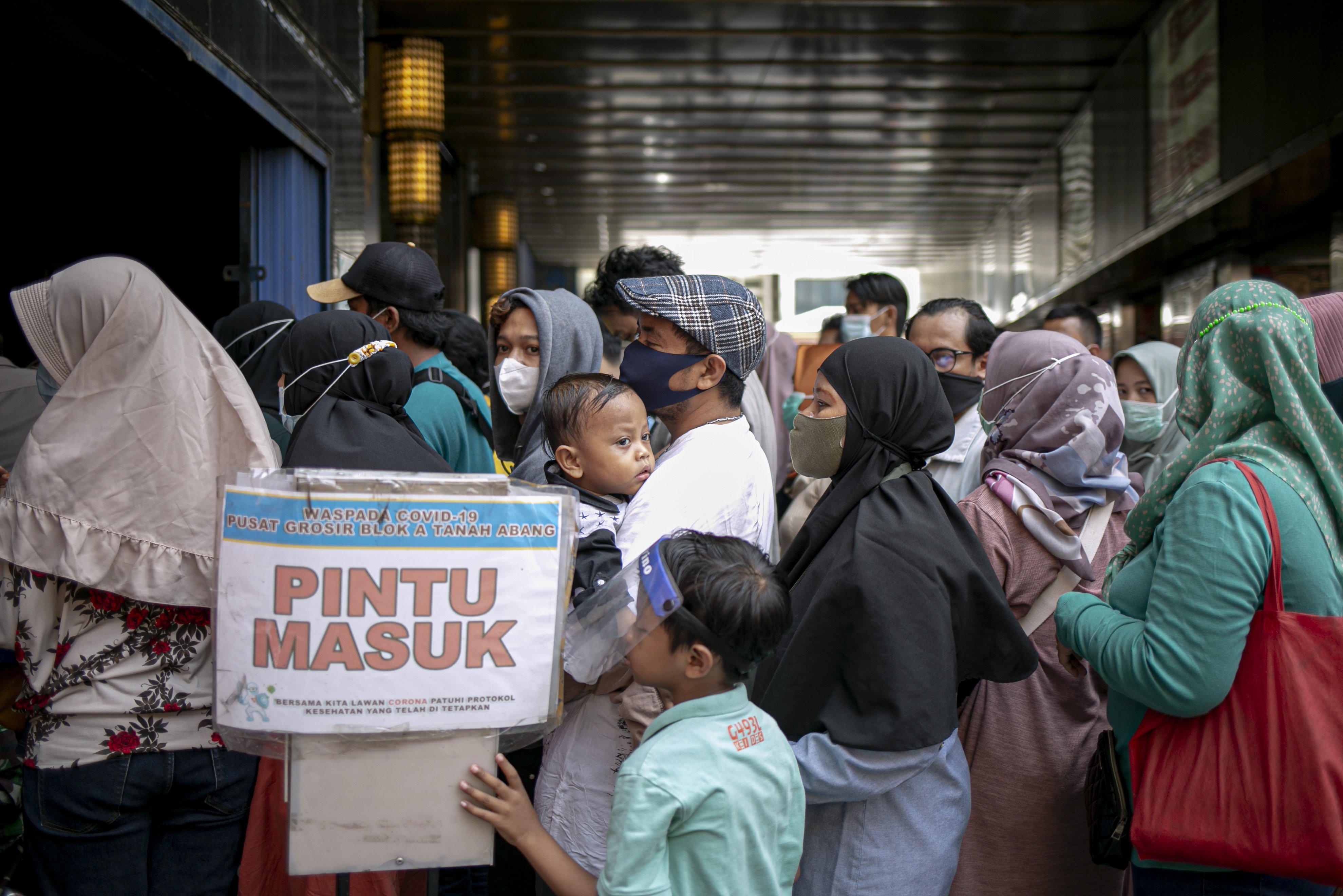 Sejumlah warga mengantre giliran masuk di Pasar Tanah Abang Blok A, Jakarta Pusat, Minggu (2/5/2021). H-10 menjelang Hari Raya Idul Fitri 1442 Hijriah kawasan tersebut mulai dipadati warga untuk berbelanja berbagai kebutuhan, guna mengantisipasi kepadatan petugas mengatur keluar masuk pengunjung.