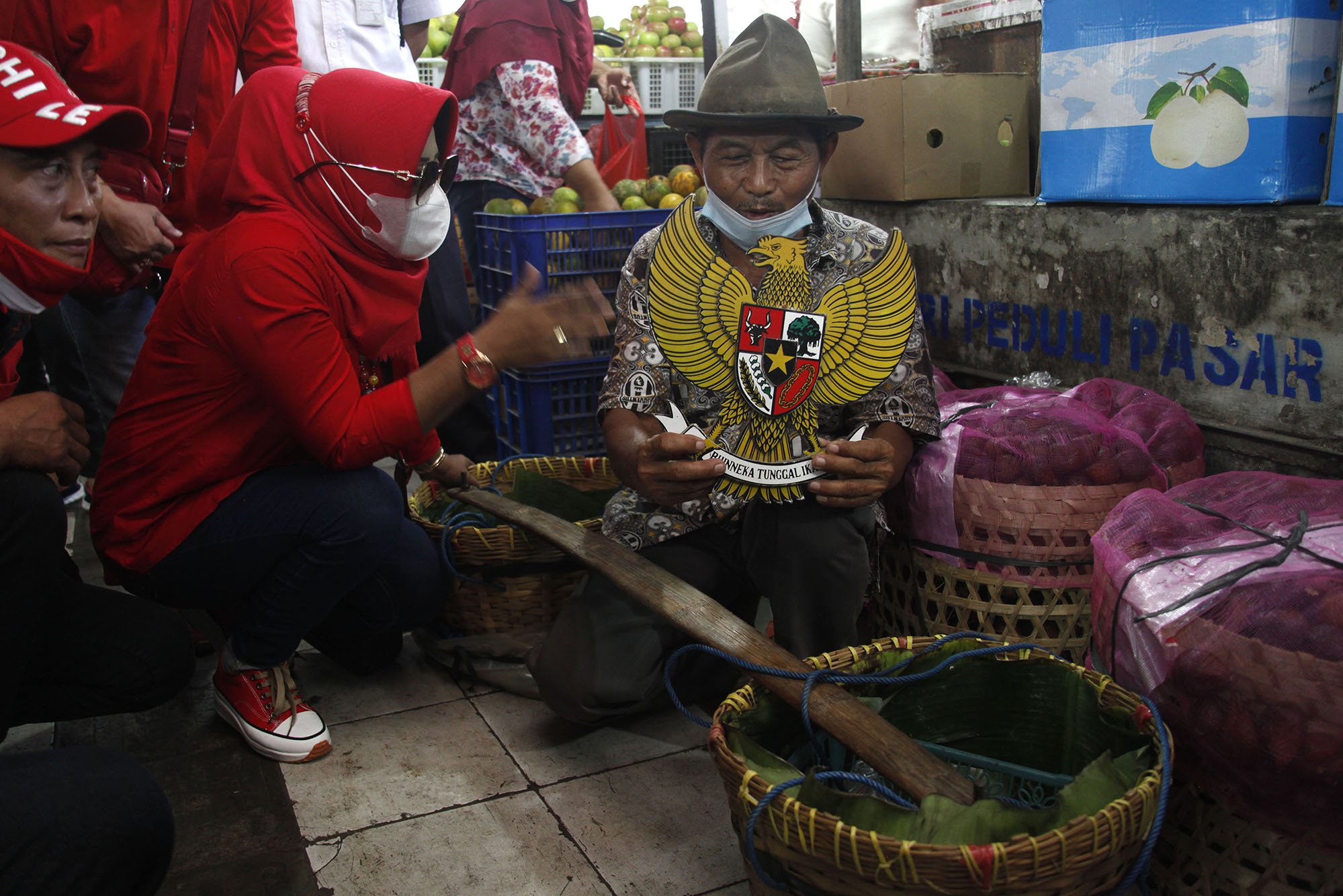 Relawan mengetes pedagang untuk menyanyikan lagu Garuda Pancasila di Pasar Gede Solo, Jawa Tengah, Selasa (1/6/2021). Aksi tersebut digelar untuk memperingati Hari Lahir Pancasila. ANTARA FOTO/Maulana Surya/aww.