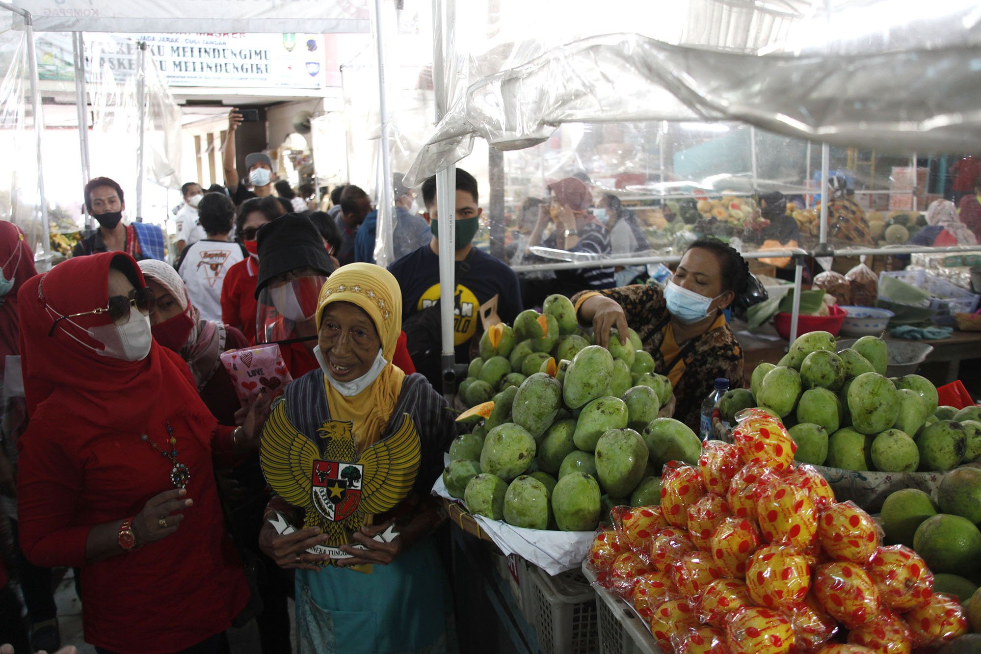 Relawan mengetes pedagang untuk menyanyikan lagu Garuda Pancasila di Pasar Gede Solo, Jawa Tengah, Selasa (1/6/2021). Aksi tersebut digelar untuk memperingati Hari Lahir Pancasila. ANTARA FOTO/Maulana Surya/aww.
