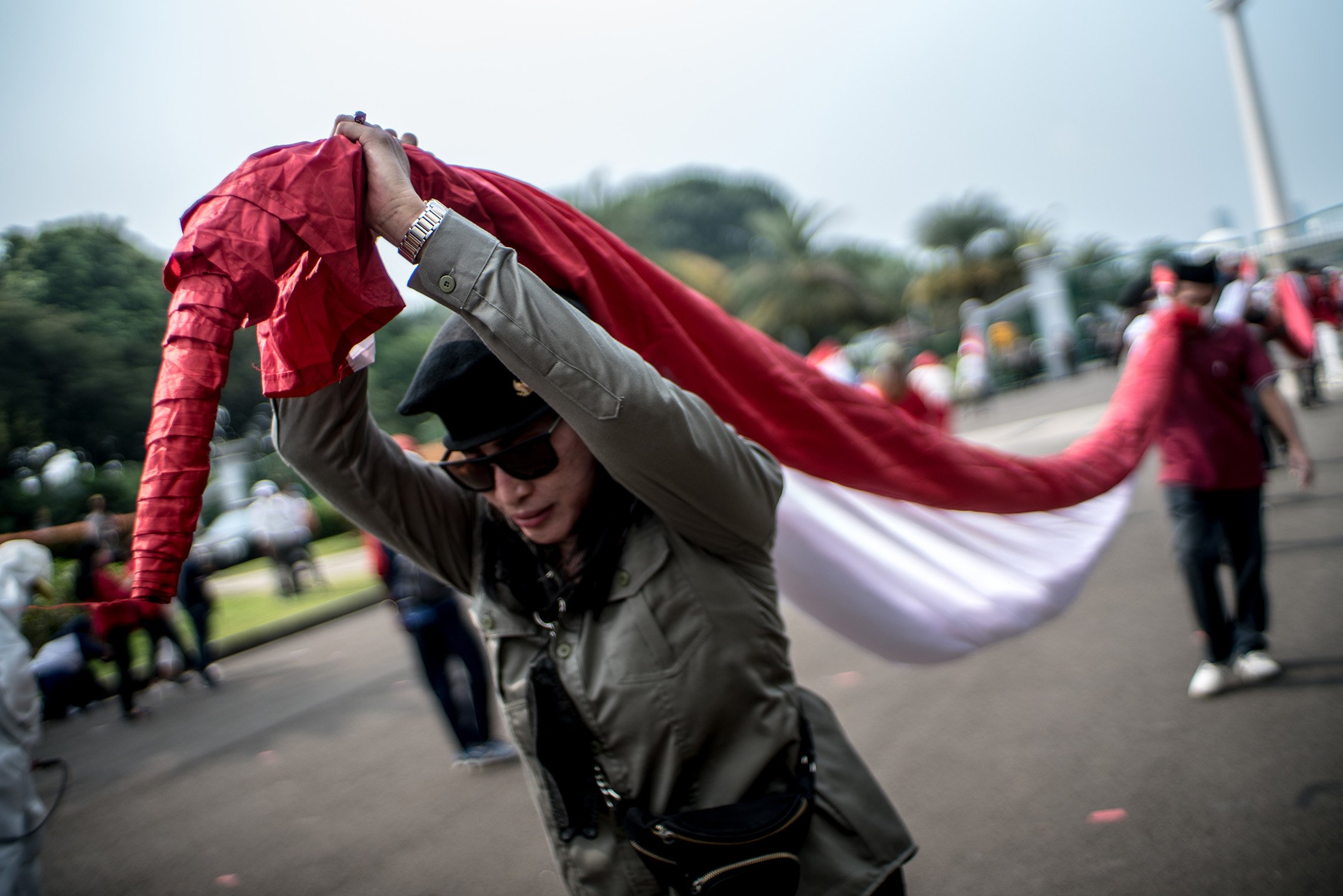 Sejumlah relawan yang tergabung dalam Gerakan Jaga Indonesia (GJI) mengibarkan bendera merah putih raksasa di Patung Kuda, Jalan Merdeka Barat, Jakarta Pusat, Rabu (2/6/2021). Pengibaran bendera merah putih raksasa tersebut dilakukan masa aksi dalam memperingati hari lahir pancasila.