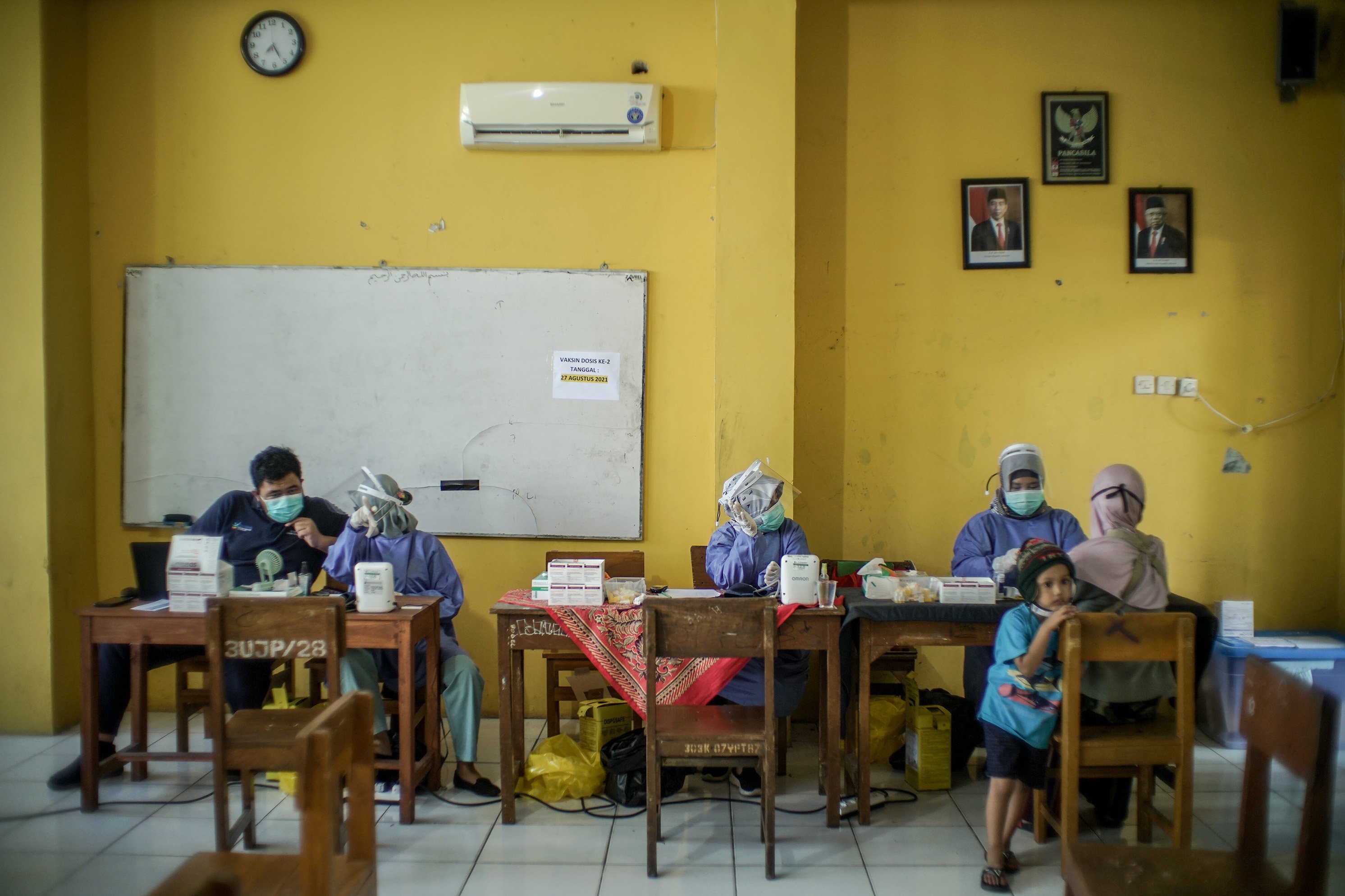 Petugas medis melakukan tes kesehatan kepada warga RT 03/RW 03, Kelurahan Cilangkap, Cipayung, Jakarta Timur,Kamis (3/6/2021). Vaksinasi massal dilakukan usai ratusan orang dari kawasan tersebut terkonfirmasi positif Covid-19. Vaksinasi diberikan kepada warga yang sebelumnya telah dinyatakan negatif Covid-19 hasil swab PCR.