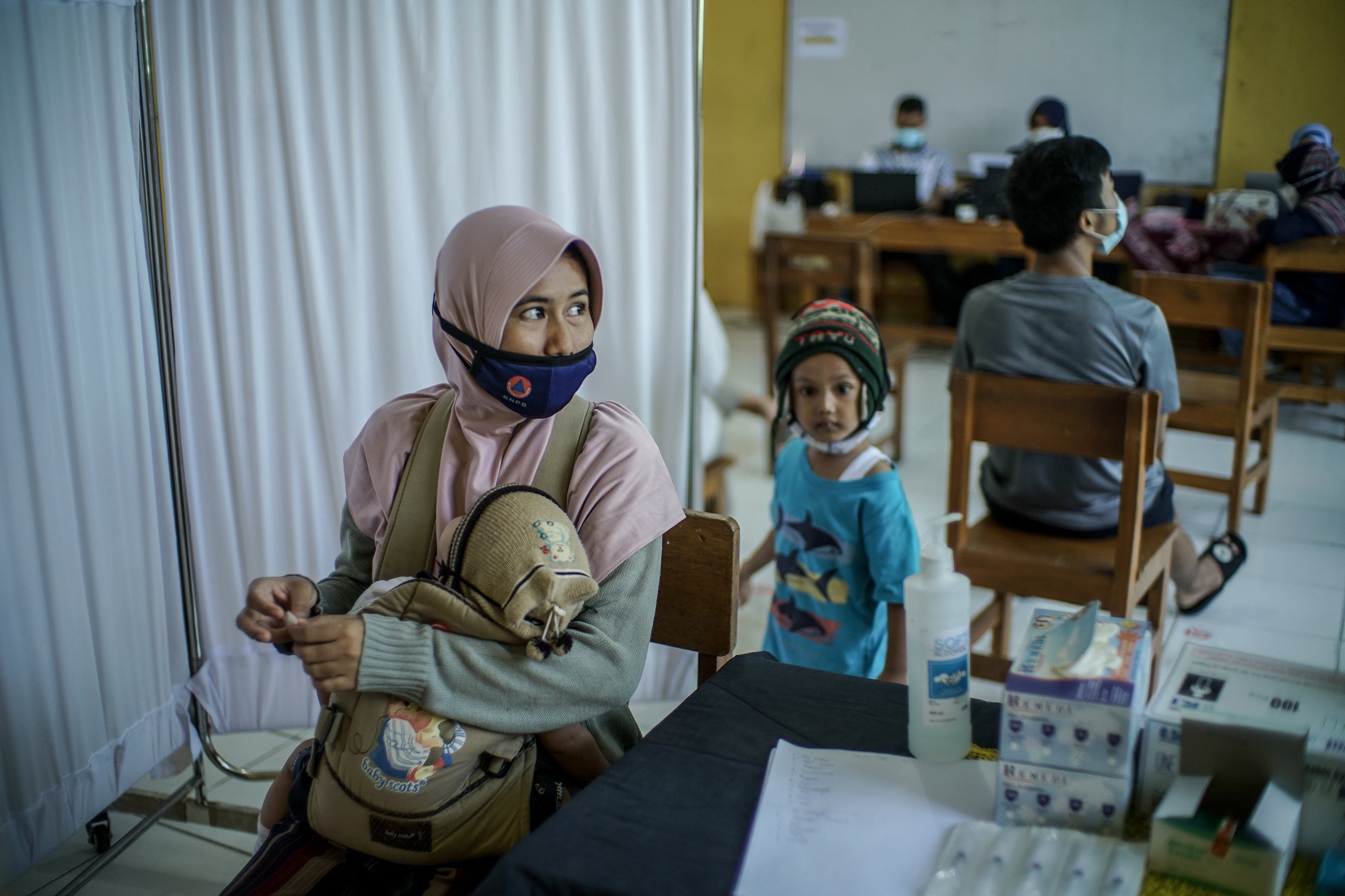 Sejumlah warga RT 03/RW 03, Kelurahan Cilangkap, Cipayung, Jakarta Timur bersiap untuk melakukan suntik vaksin,Kamis (3/6/2021). Vaksinasi massal dilakukan usai ratusan orang dari kawasan tersebut terkonfirmasi positif Covid-19. Vaksinasi diberikan kepada warga yang sebelumnya telah dinyatakan negatif Covid-19 hasil swab PCR.
