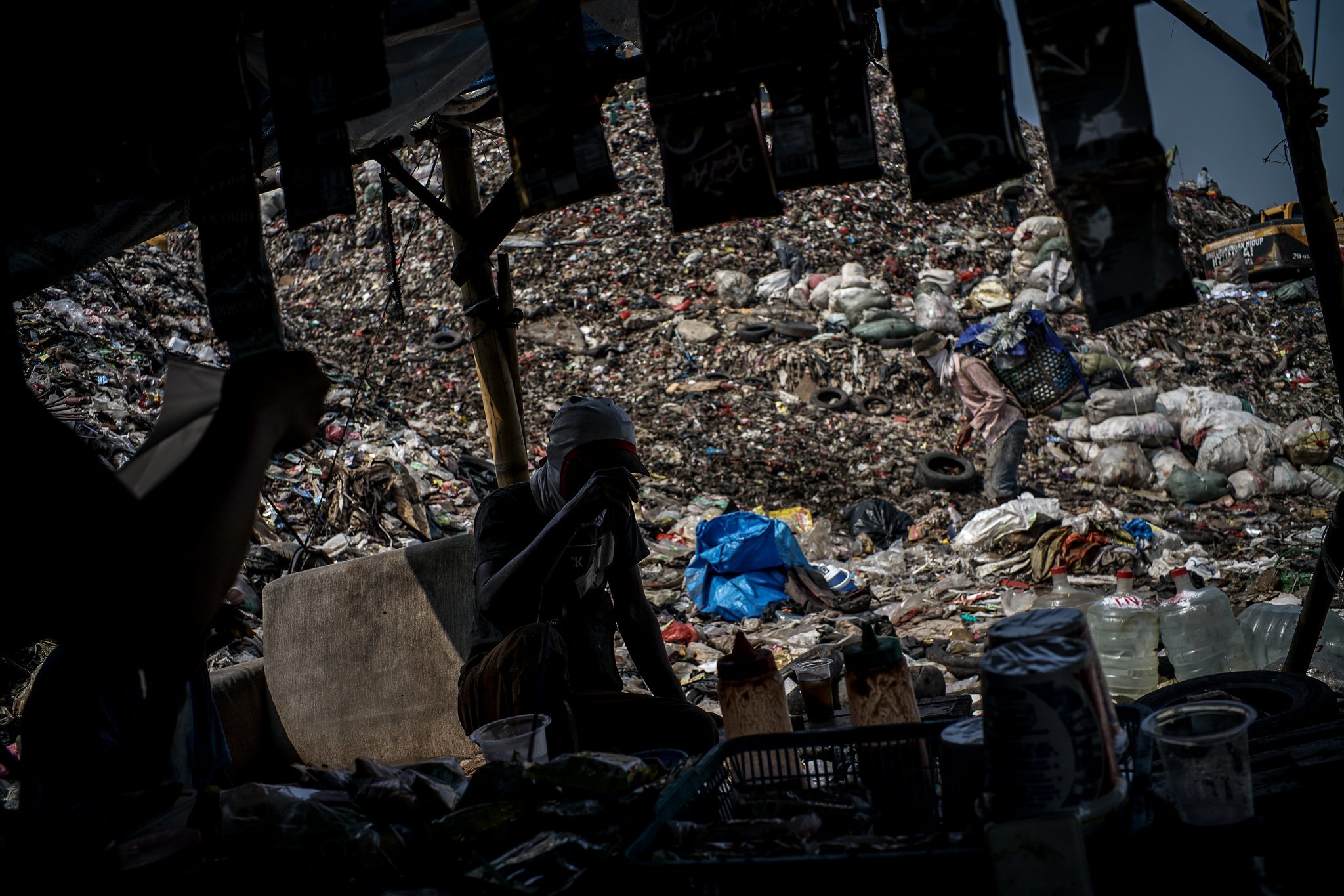 Pemungut sampah beristirahat usai memilah sampah rumah tangga yang bisa dimanfaatkan untuk dijual kembali di Tempat Pengolahan Sampah Terpadu (TPST) Bantar Gebang, Bekasi, Jawa Barat (5/6/2021). Pandemi Covid-19 secara tidak langsung berdampak pada pengurangan volume sampah yang masuk ke TPST tersebut dan memengaruhi penghasilan pemungut sampah. 