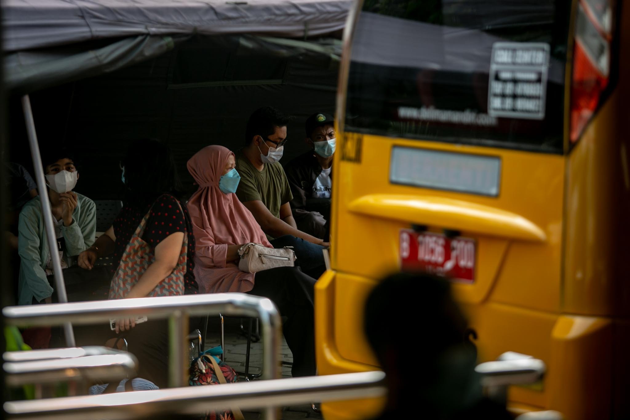 Sejumlah masyarakat yang terkonfirmasi positif Covid-19 menjalani pendataan sebelum diberangkatkan menggunakan bus sekolah untuk dirujuk ke sejumlah lokasi penanganan Covid-19 di Puskesmas Kecamatan Pasar Minggu, Jakarta, Sabtu, (12/6/2021). Berdasarkan data dari Satuan Tugas Penanganan Covid-19, jumlah pasien di Jakarta per Kamis, (10/6/2021) alami angka kenaikan yang cukup drastis.