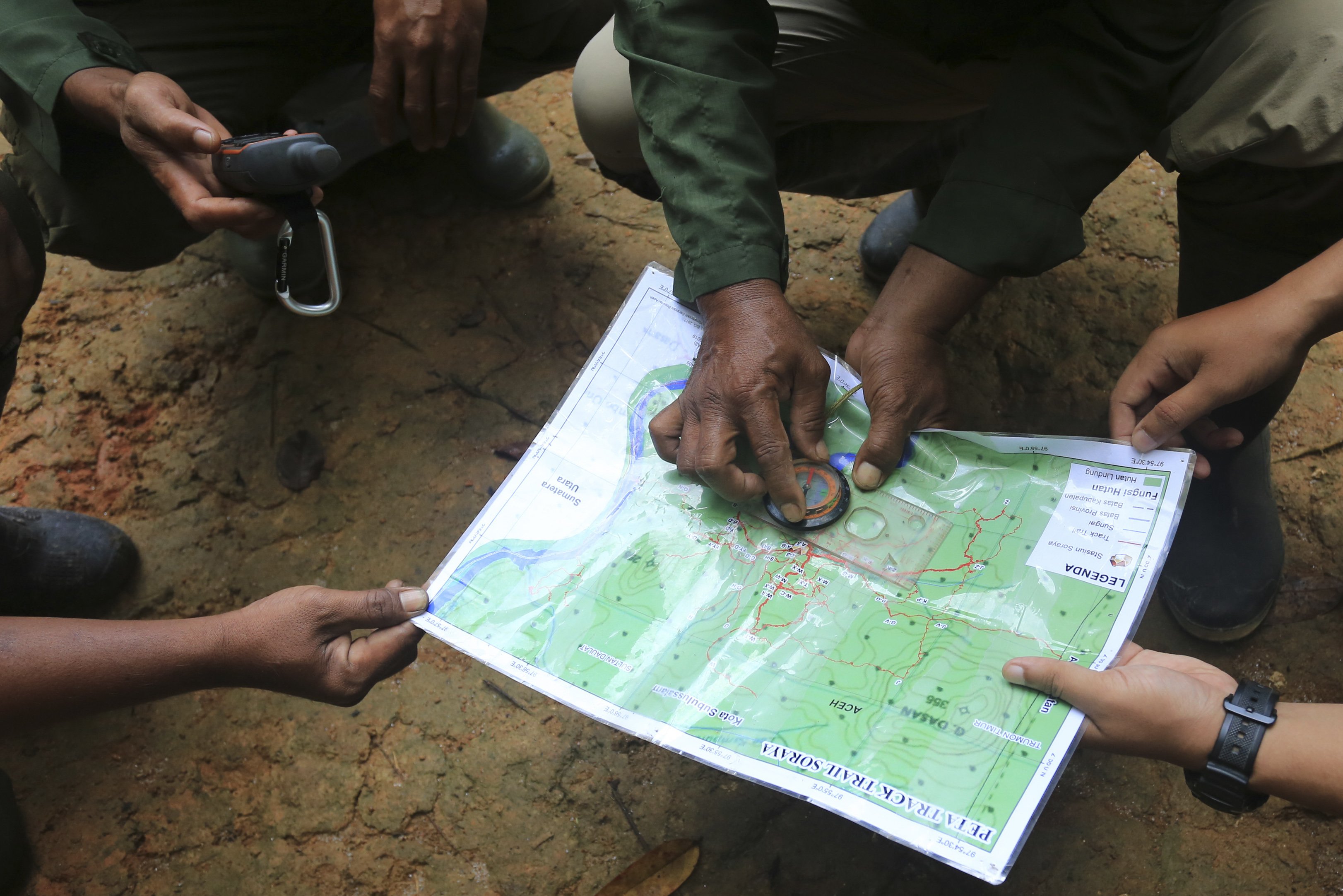 Anggota Jagawana mengamati sebuah peta saat menentukan posisi patroli di Kawasan Ekosistem Leuser