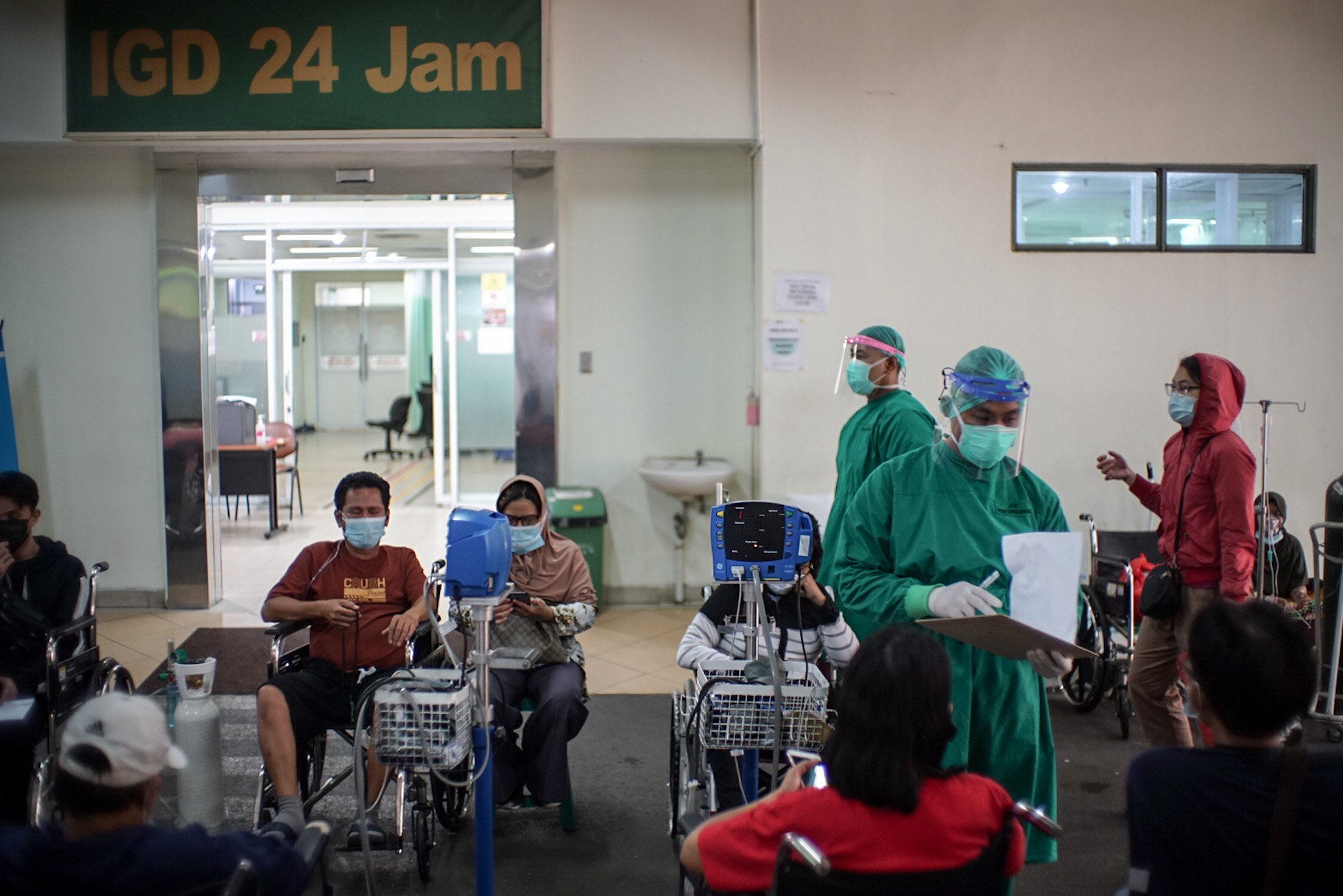 Petugas medis mengenakan Alat Pelindung Diri (APD) lengkap merawat pasien Covid-19 yang menunggu di pelataran untuk mendapatkan tempat tidur perawatan di IGD RSUD Cengkareng, Jakarta Barat, Rabu, (23/6/2021). Sejak awal bulan Juni 2021 atau setelah libur lebaran hingga saat ini lonjakan pasien positif Covid-19 terus terjadi sehingga rumah sakit kewalahan dan kehabisan tempat perawatan.