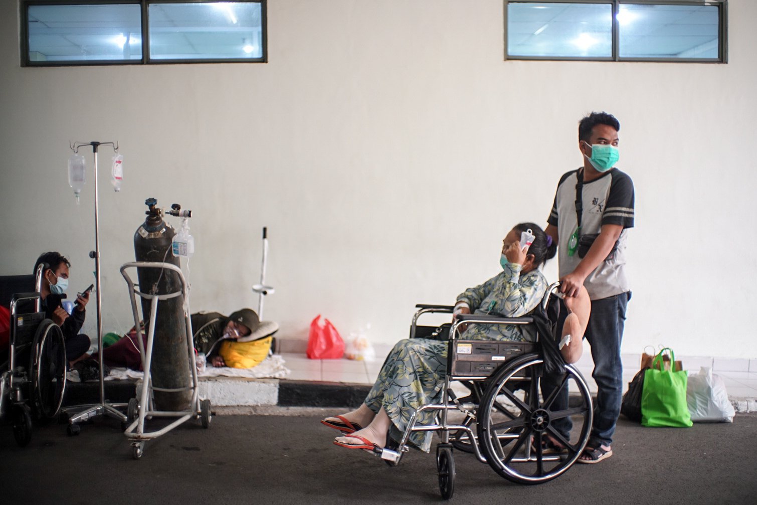 Keluarga korban pasien Covid-19 menunggu di pelataran untuk anggota keluarganya yang terpapar Covid-19 bisa mendapatkan tempat tidur perawatan di IGD RSUD Cengkareng, Jakarta Barat, Rabu, (23/6/2021). Sejak awal bulan Juni 2021 atau setelah libur lebaran hingga saat ini lonjakan pasien positif Covid-19 terus terjadi sehingga rumah sakit kewalahan dan kehabisan tempat perawatan.