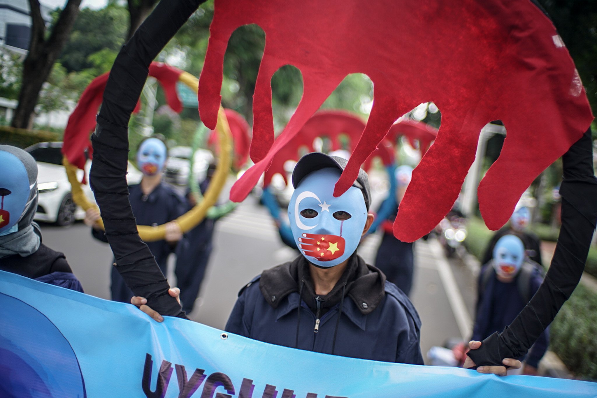 Massa aksi menggunakan topeng etnis Uyghur melakukan aksi damai di depan Gedung Kemenpora RI, Jakarta, Jumat (25/6/2021). Selama unjuk rasa massa aksi menuntut Kemenpora untuk memboikot Olimpiade Beijing 2022.
