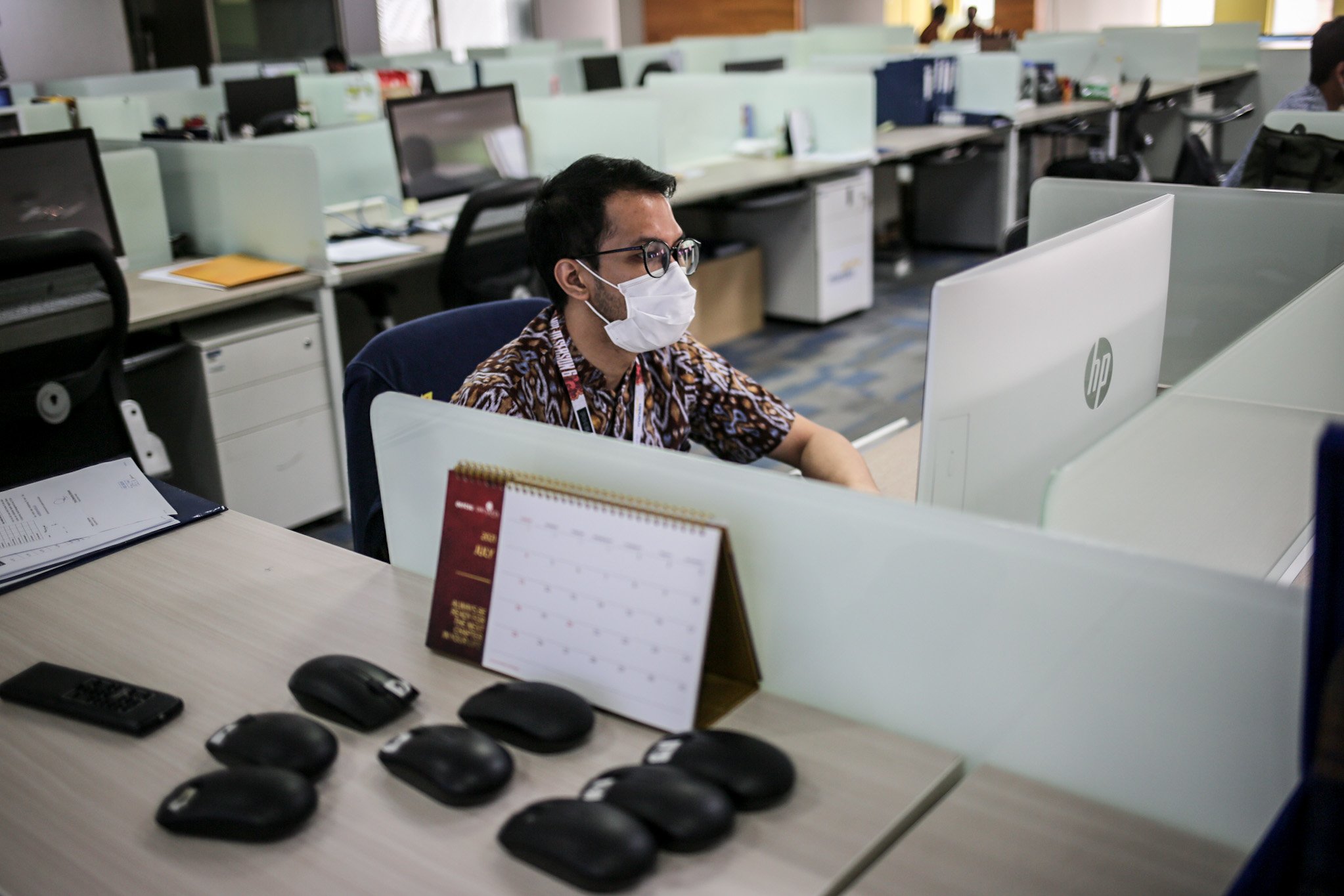 Sejumlah pekerja beraktivitas di ruang kerja di masa Penerapan Pembatasan Kegiatan Masyarakat (PPKM) Darurat di kantor perbankan wilayah Sudirman Central Business District (SCBD), Senayan, Kebayoran Baru, Jakarta Selatan, Senin, (5/7/2021). Selama penerapan PPKM Darurat sektor esensial diberlakukan 50 persen maksimum karyawan Work From Office (WFO) atau bekerja dari kantor dengan menerapkan protokol kesehatan. Sementara sektor non-esensial menerapkan 100 persen Work From Home (WFH) atau bekerja dari rumah.