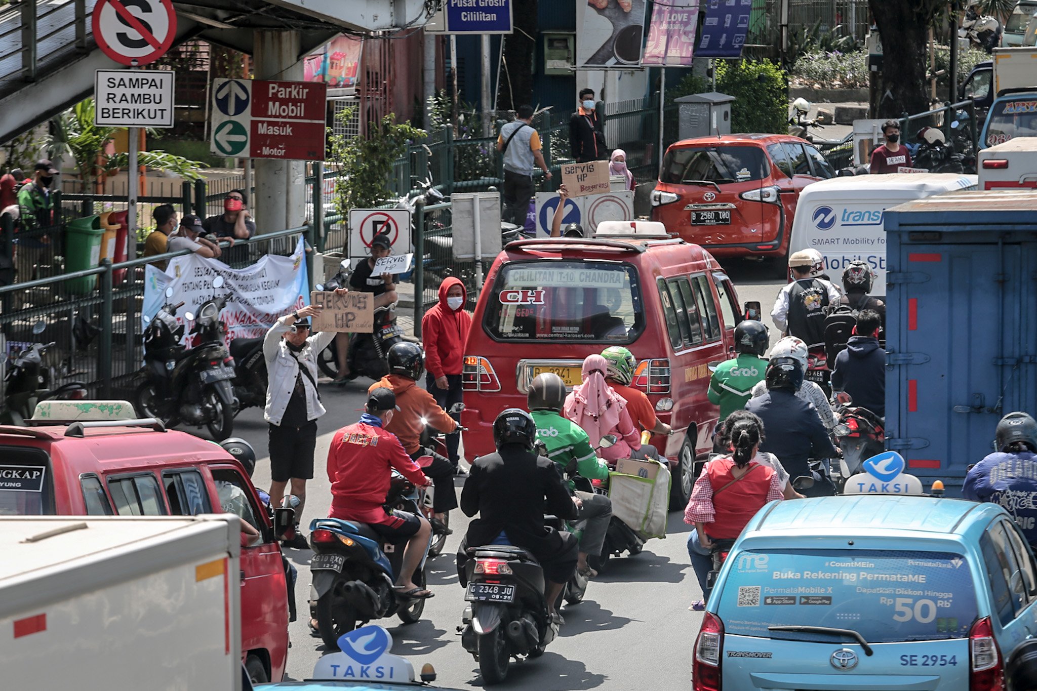 Sejumlah penjaja jasa reparasi seluler genggam berdiri di bahu jalan menawarkan jasa reparasi dan tukar tambah seluler genggam di Pusat Grosir Cililitan (PGC), Cililitan, Jakarta Timur, Selasa, (13/7/2021). Upaya tersebut dilakukan para penjaja seluler genggam yang merupakan pedagang di dalam Mal PGC akibat ditutupnya pusat perbelanjaan selama masa Pemberlakuan Pembatasan Kegiatan Masyarakat (PPKM) Darurat.
