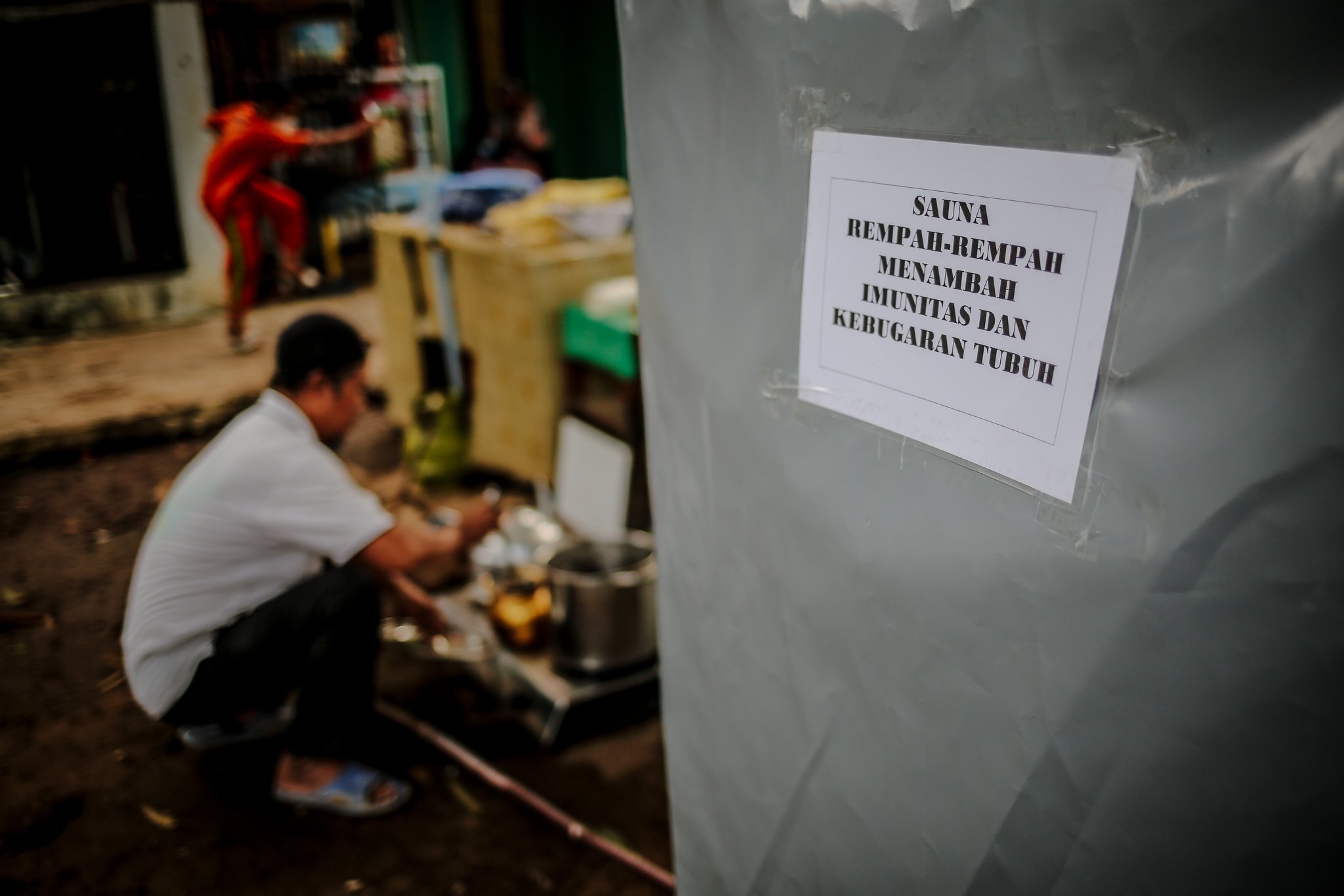 Sejumlah Warga memasukan rempah-rempah ke dalam ceret yang dipanaskan menggunakan kompor gas untuk menimbulkan uap dan disalirkan ke bilik sauna menggunakan pipa di kawasan Gang Pepaya RT 11 RW 3, Lenteng Agung, Jagakarsa, Jakarta, Senin (19/7/2021).