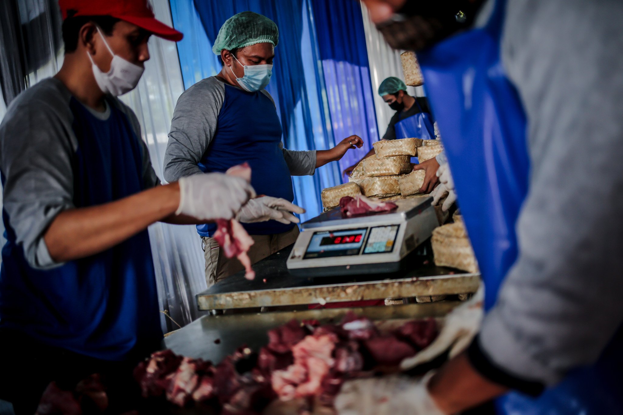Petugas menyelesaikan pengemasan daging hewan kurban ke dalam besek yang sudah disiapkan di Rumah Potong Hewan (RPH) PD Dahrma Jaya, Penggilingan, Cakung, Jakarta, Rabu, (21/7/2021).