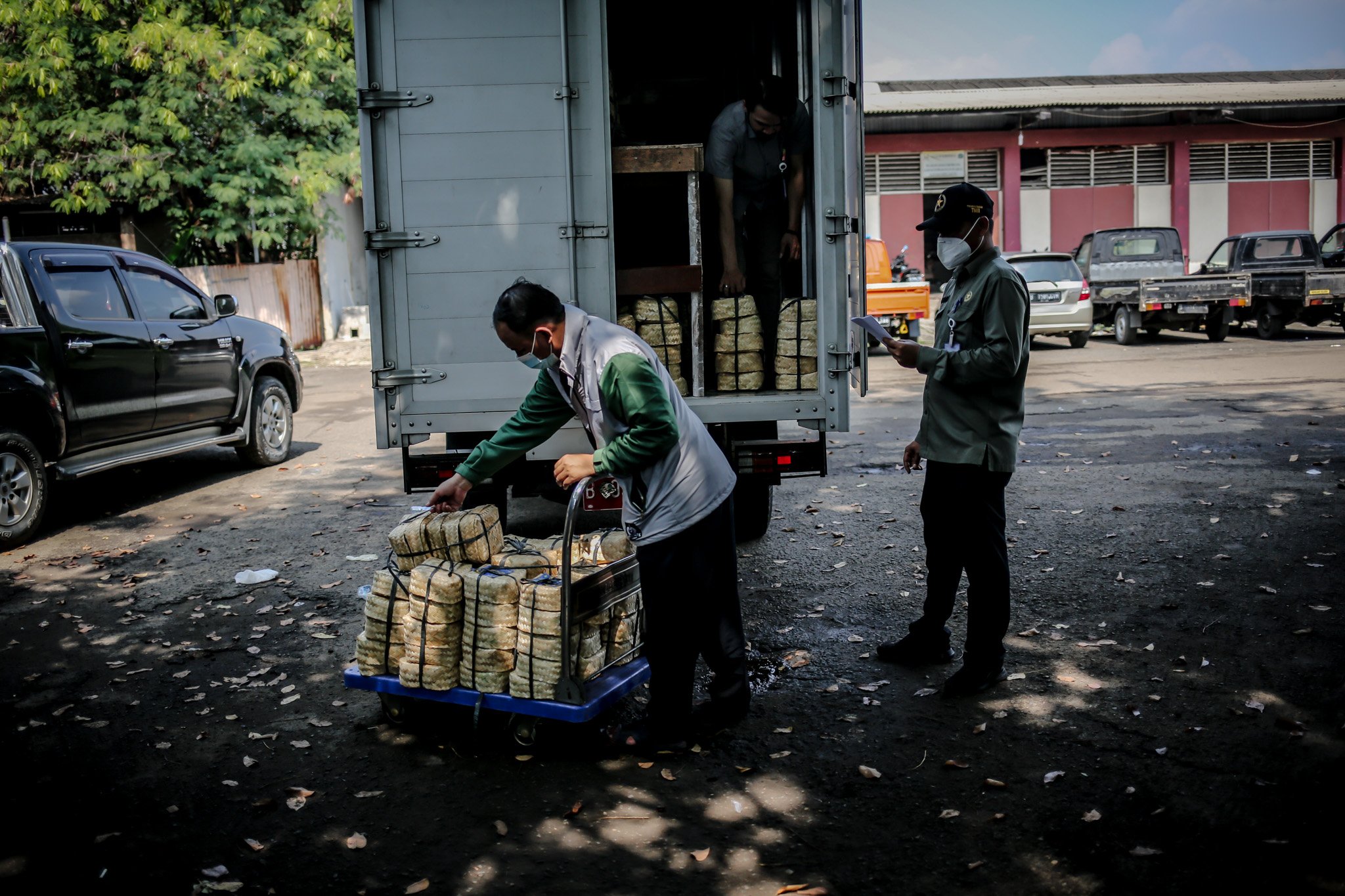 Petugas memindahkan daging hewan kurban yang dibungkus dengan besek ke dalam truk untuk di distribusi kembali di Rumah Potong Hewan (RPH) PD Dahrma Jaya, Penggilingan, Cakung, Jakarta, Rabu, (21/7/2021).
