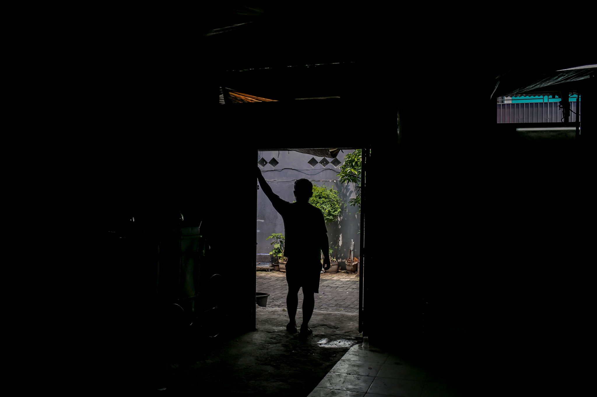 Pekerja melongok ke luar ruangan saat sepi permintaan di rumah produksi kerupuk Melati, Menteng Atas, Jakarta Selatan, Jumat, (23/7/20221). Semenjak penerapan Pemberlakuan Pembatasan Kegiatan Masyarakat (PPKM) Darurat rumah produksi kerupuk yang sudah berdiri sejak tahun 1960 ini alami penurunan omzet hingga 40%.