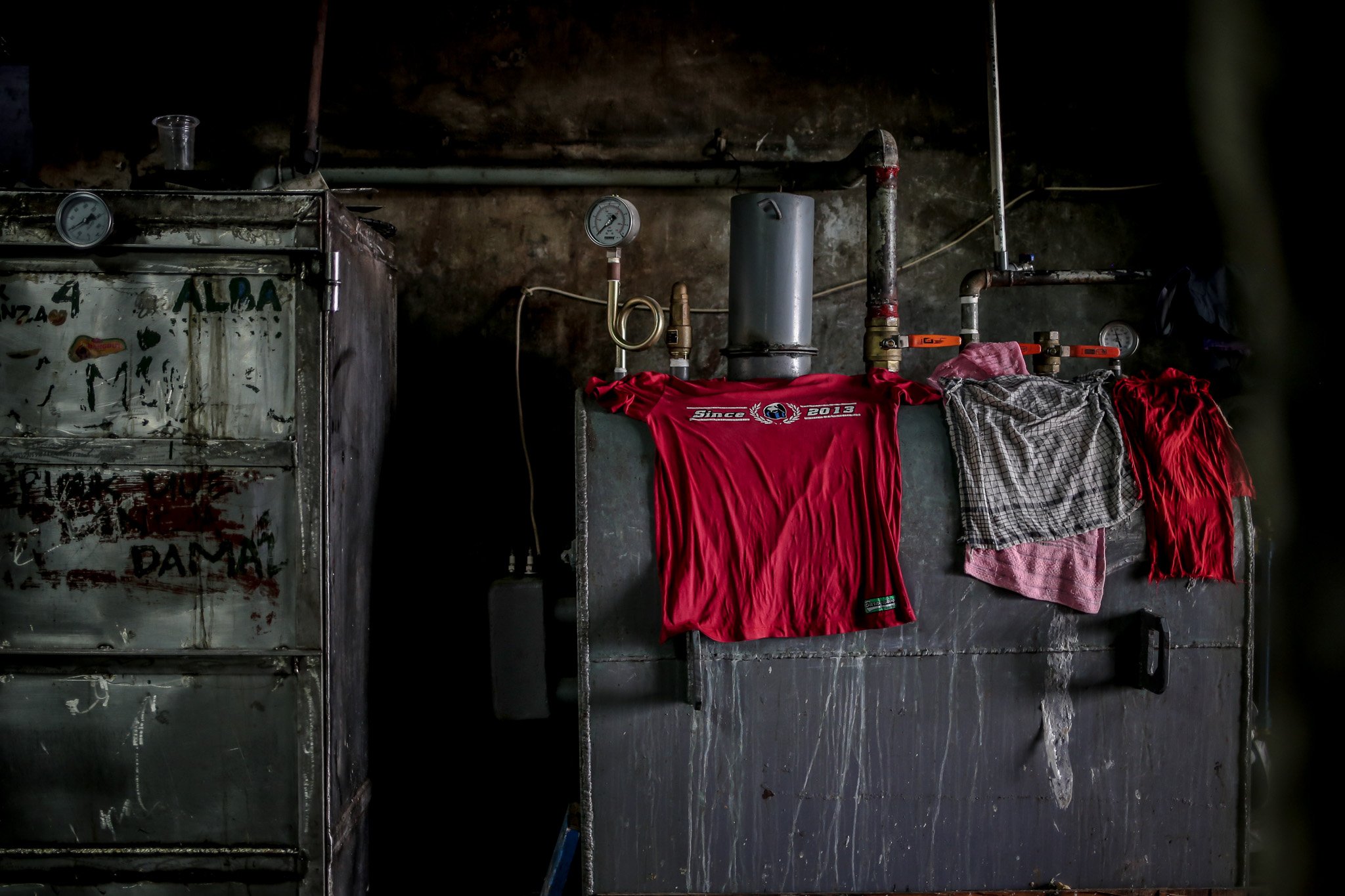 Pekerja menjemur pakaiannya diatas mesin oven di rumah produksi kerupuk Melati, Menteng Atas, Jakarta Selatan, Jumat, (23/7/20221)