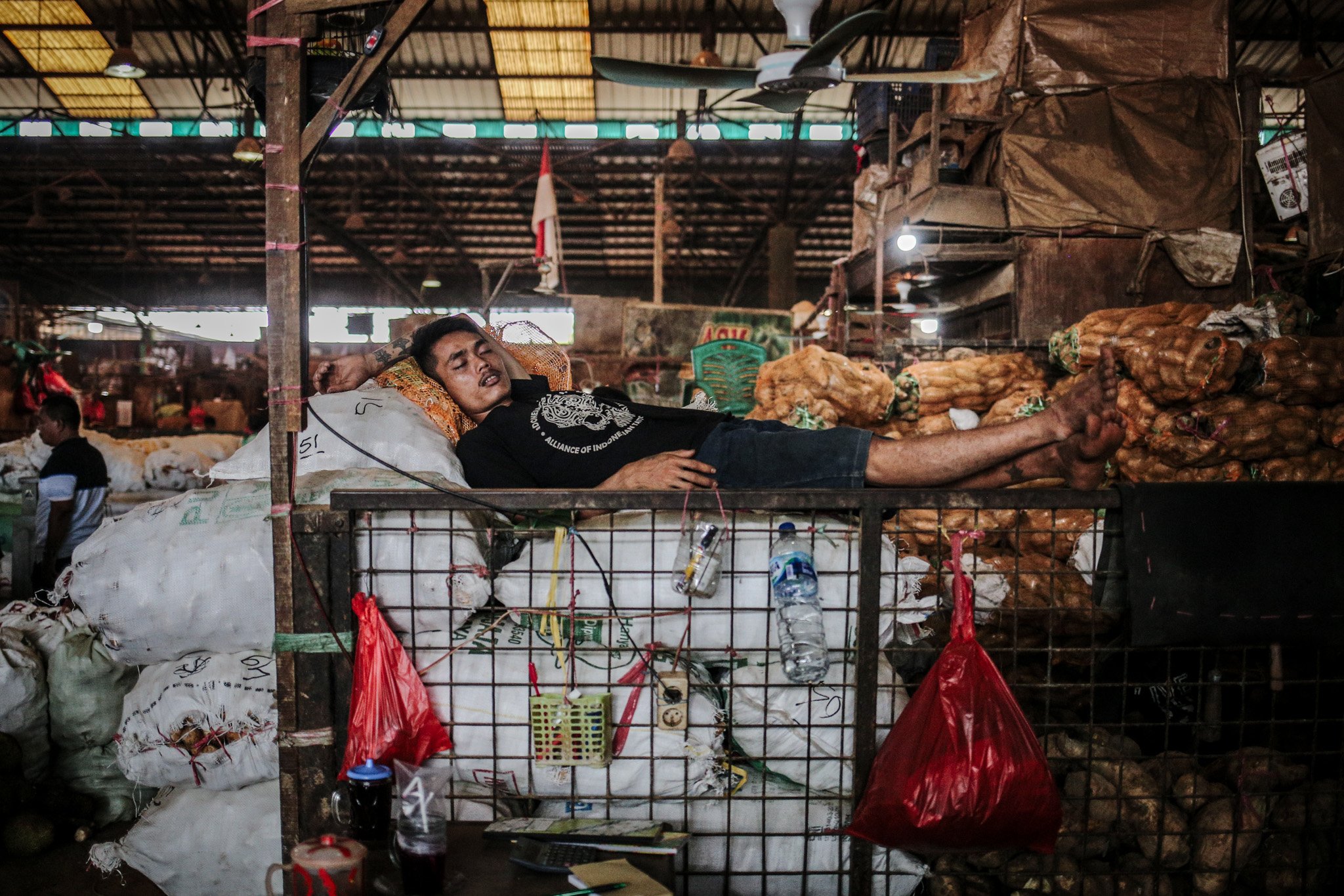 Seorang pedagang tertidur lelap di lapak buah miliknya di Pasar Induk Kramat Jati, Ciracas, Jakarta Timur, Rabu (28/7/2021). Imbas penerapan Pemberlakuan Pembatasan Kegiatan Masyarakat (PPKM) level 4 para pedagang mengaku alami penurunan pendapatan hingga 50%.