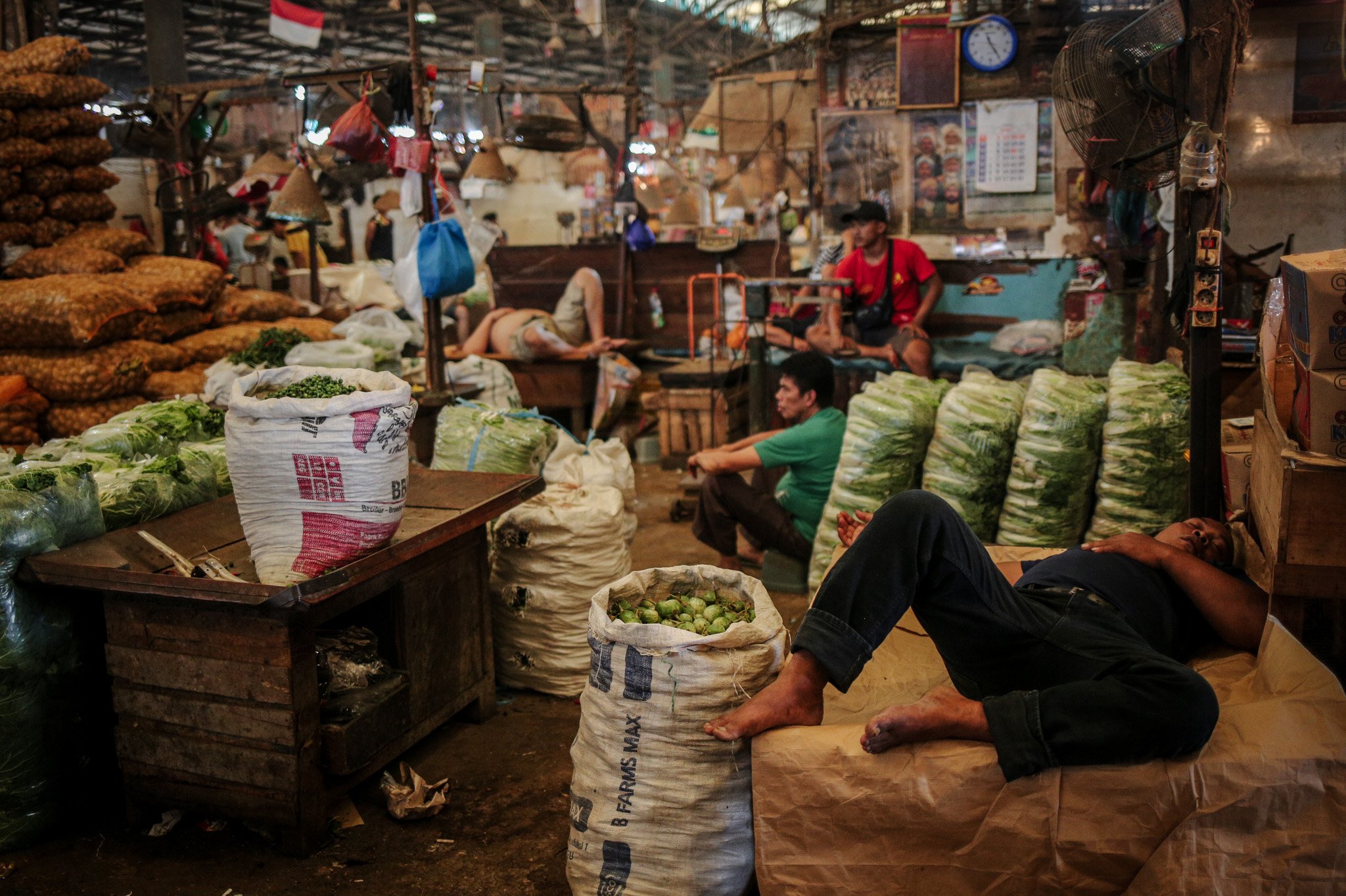 Sejumlah pedagang tertidur lelap di lapak sayur miliknya di Pasar Induk Kramat Jati, Ciracas, Jakarta Timur, Rabu (28/7/2021). Imbas penerapan Pemberlakuan Pembatasan Kegiatan Masyarakat (PPKM) level 4 para pedagang mengaku alami penurunan pendapatan hingga 50%.