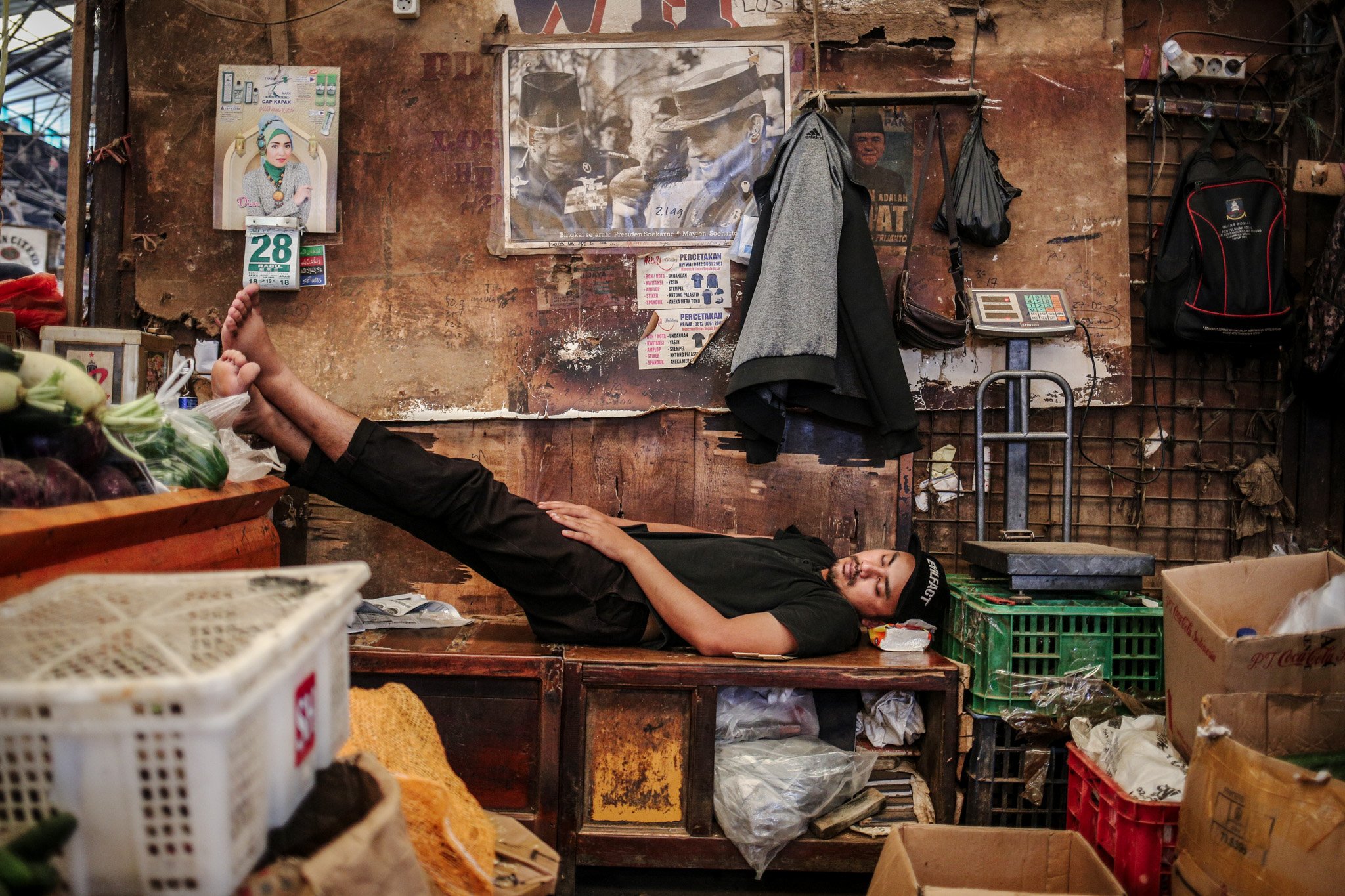 Seorang pedagang tertidur lelap di lapak sayur miliknya di Pasar Induk Kramat Jati, Ciracas, Jakarta Timur, Rabu (28/7/2021). Imbas penerapan Pemberlakuan Pembatasan Kegiatan Masyarakat (PPKM) level 4 para pedagang mengaku alami penurunan pendapatan hingga 50%.